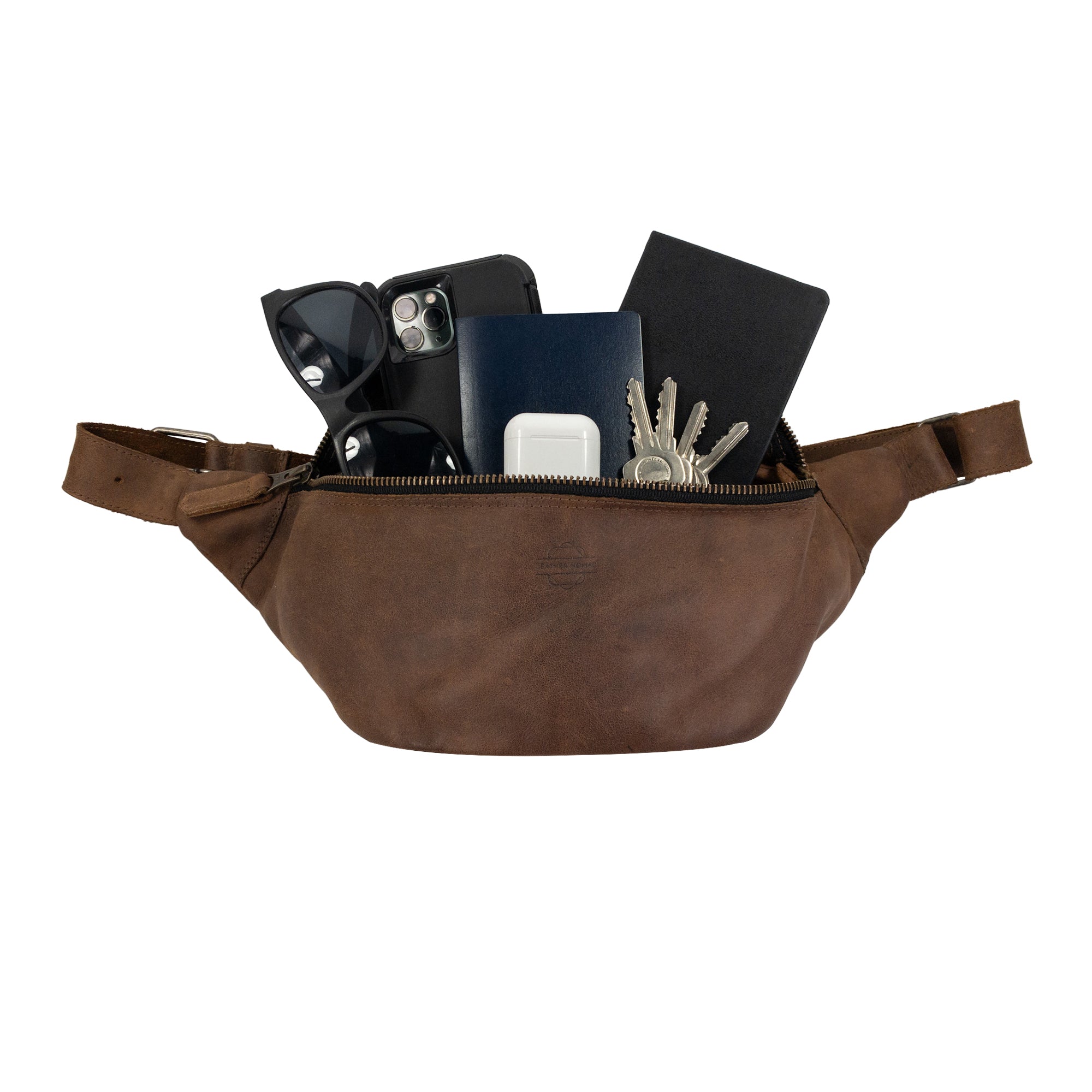 Zippered Fanny Pack by Leather Nomad filled with essentials like sunglasses and phone. This handmade waist bag made from full grain leather is stylish and functional for travel, showcasing artisan craftsmanship through hand cut and hand sewn techniques in La Antigua Guatemala.