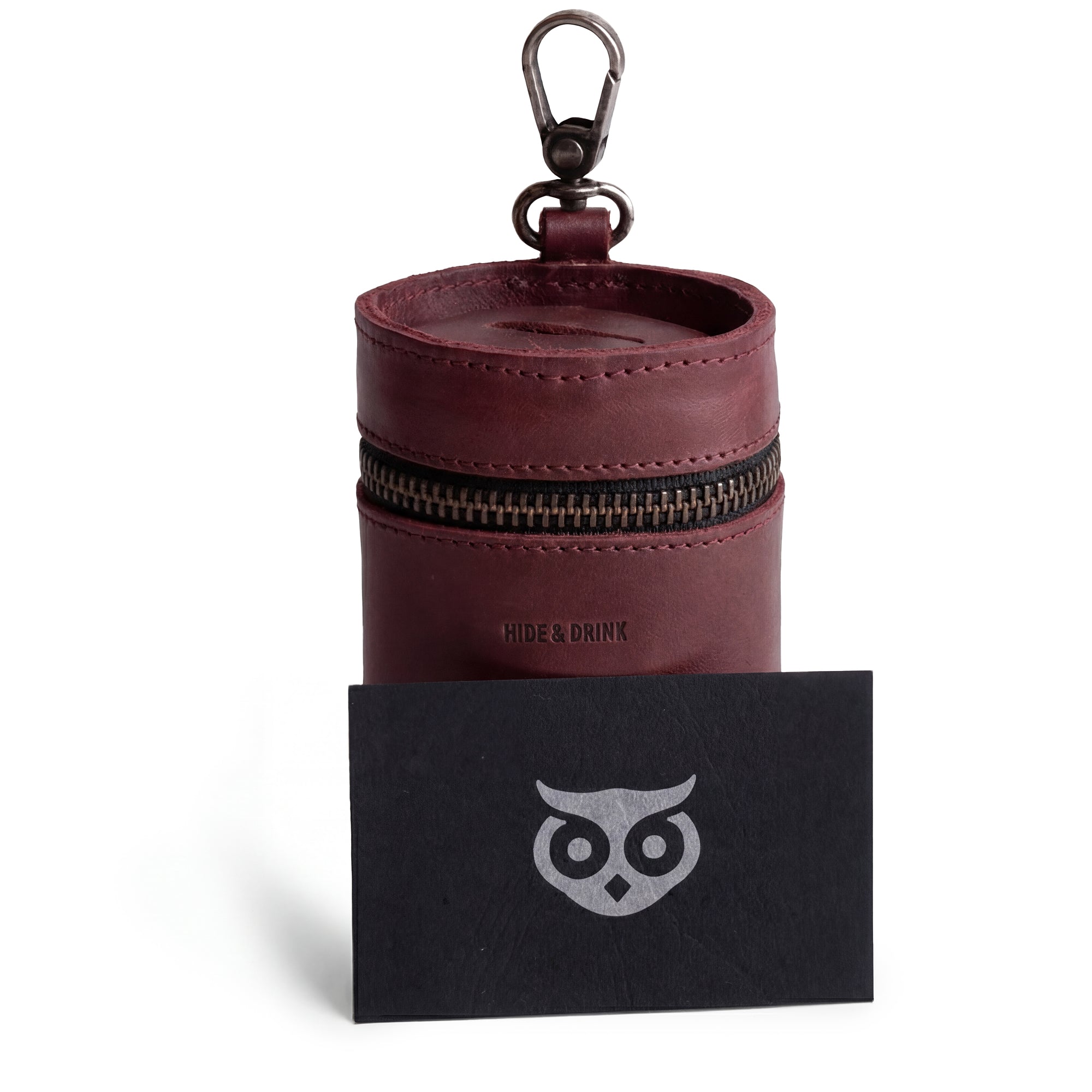 The Bucket Coin Release from Hide & Drink, paired with a branding card. This image captures the essence of an artisan-made piggy bank bucket that is both functional and stylish, reflecting the brand's commitment to quality with its full grain leather and handcrafted details.