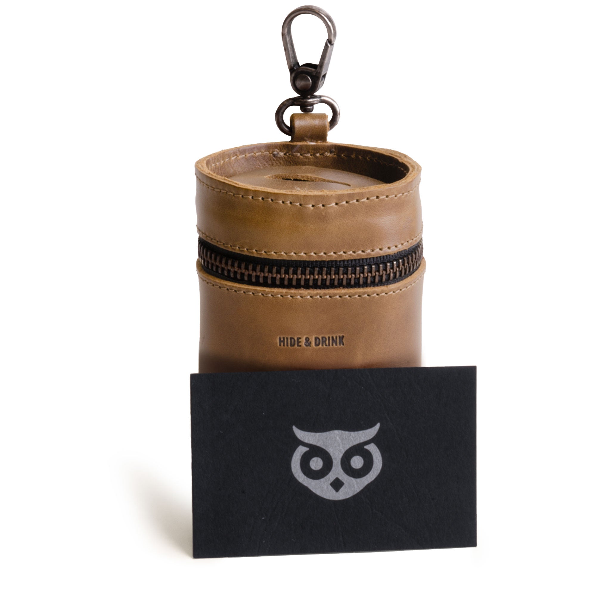 The Bucket Coin Release by Hide & Drink presented alongside a card, featuring a durable design in Full Grain Leather. This zippered pouch is not just an aesthetic Coin Case but also an effective Cash Organizer, proudly handmade in La Antigua Guatemala & Oaxaca Mexico.