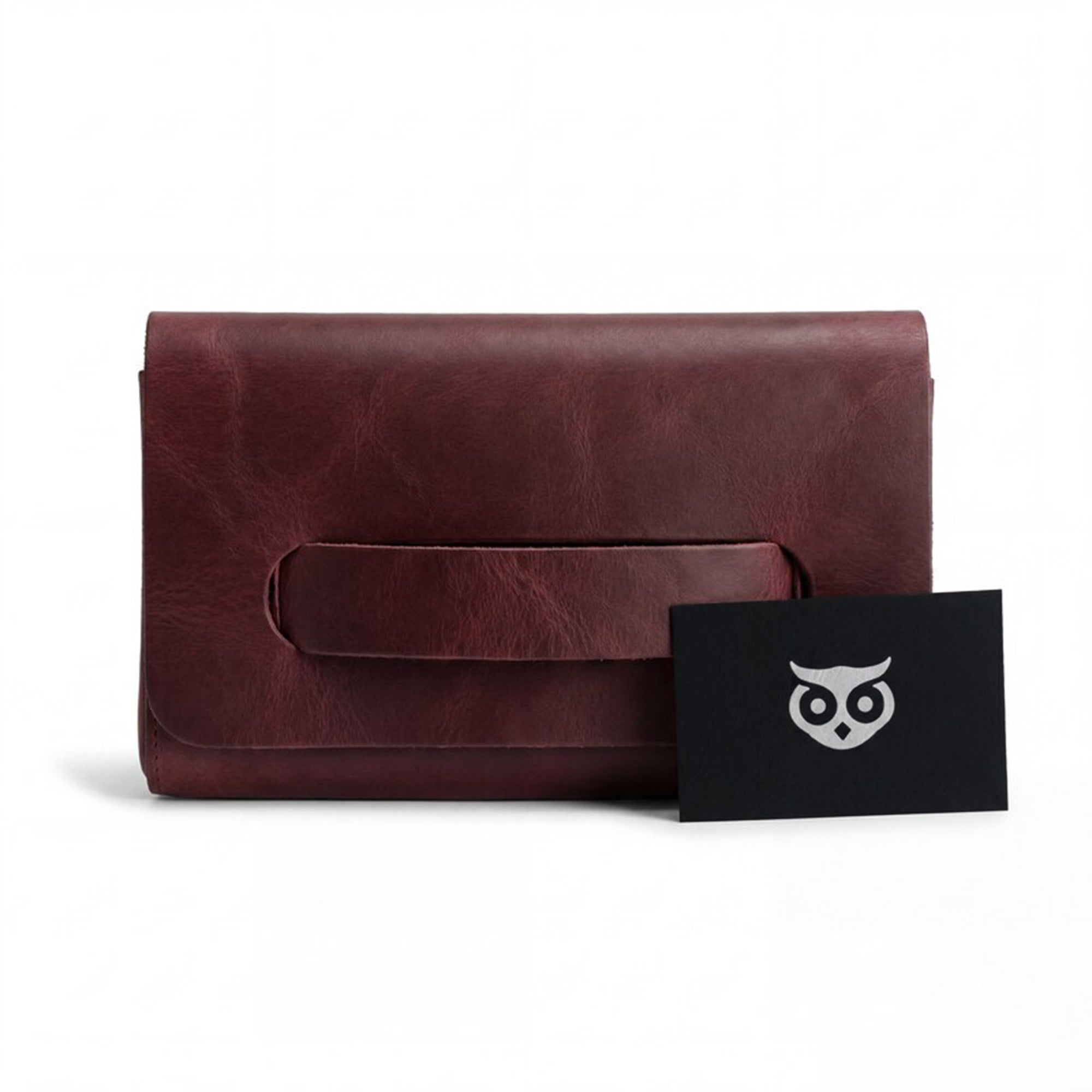 The maroon Clutch Bag With Handle from Hide & Drink, stylishly displayed with included accessories. This Full Grain Leather Clutch Bag is a fabulous gift for women, expertly handcrafted in La Antigua Guatemala & Oaxaca Mexico.