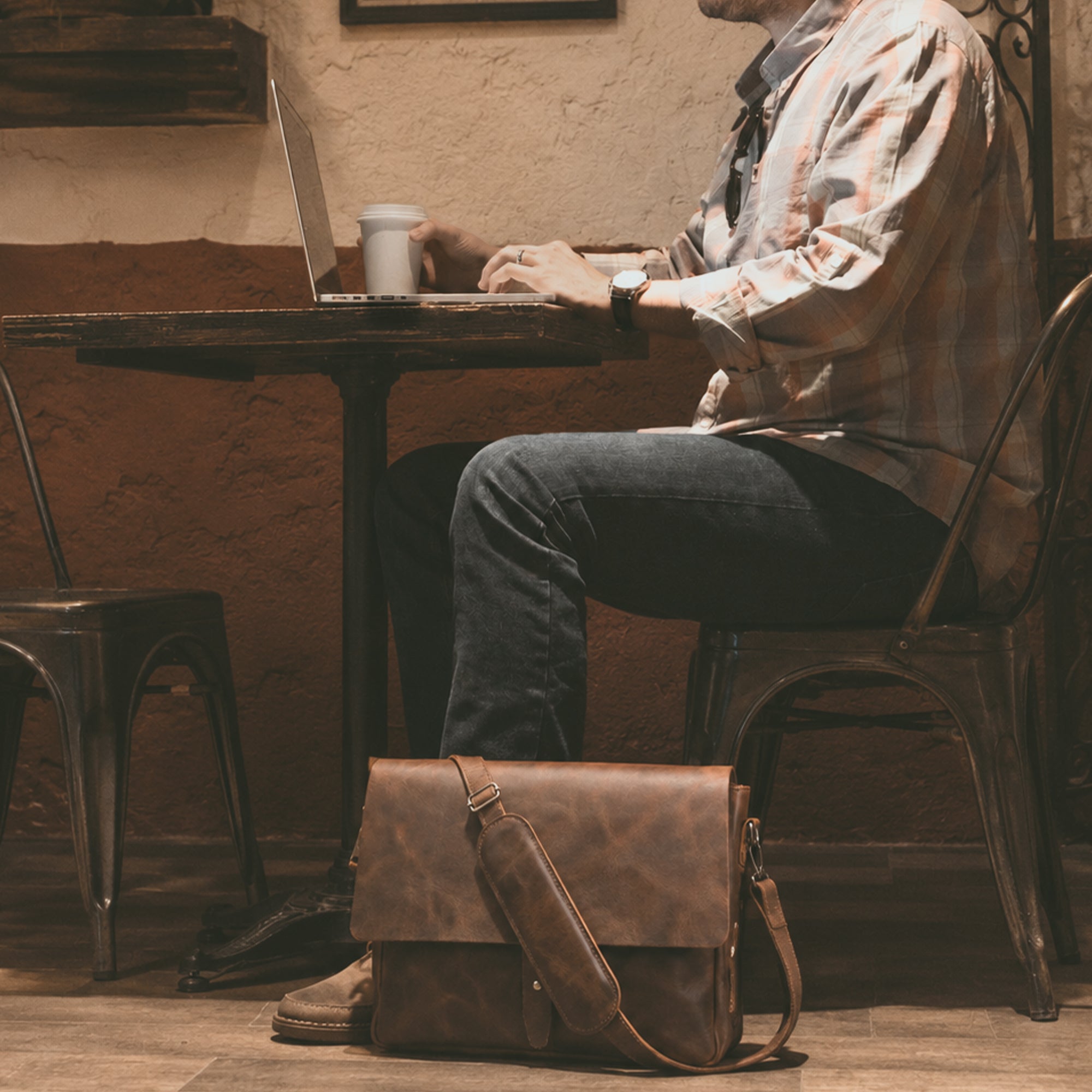 Side view of Hide & Drink's Messenger Bag with Adjustable Strap, emphasizing its stylish design and full grain leather finish. Perfect as a classic portfolio or a travel accessory, this messenger bag features small batch production with hand cut and hand sewn artistry. Handmade in La Antigua Guatemala & Oaxaca Mexico.
