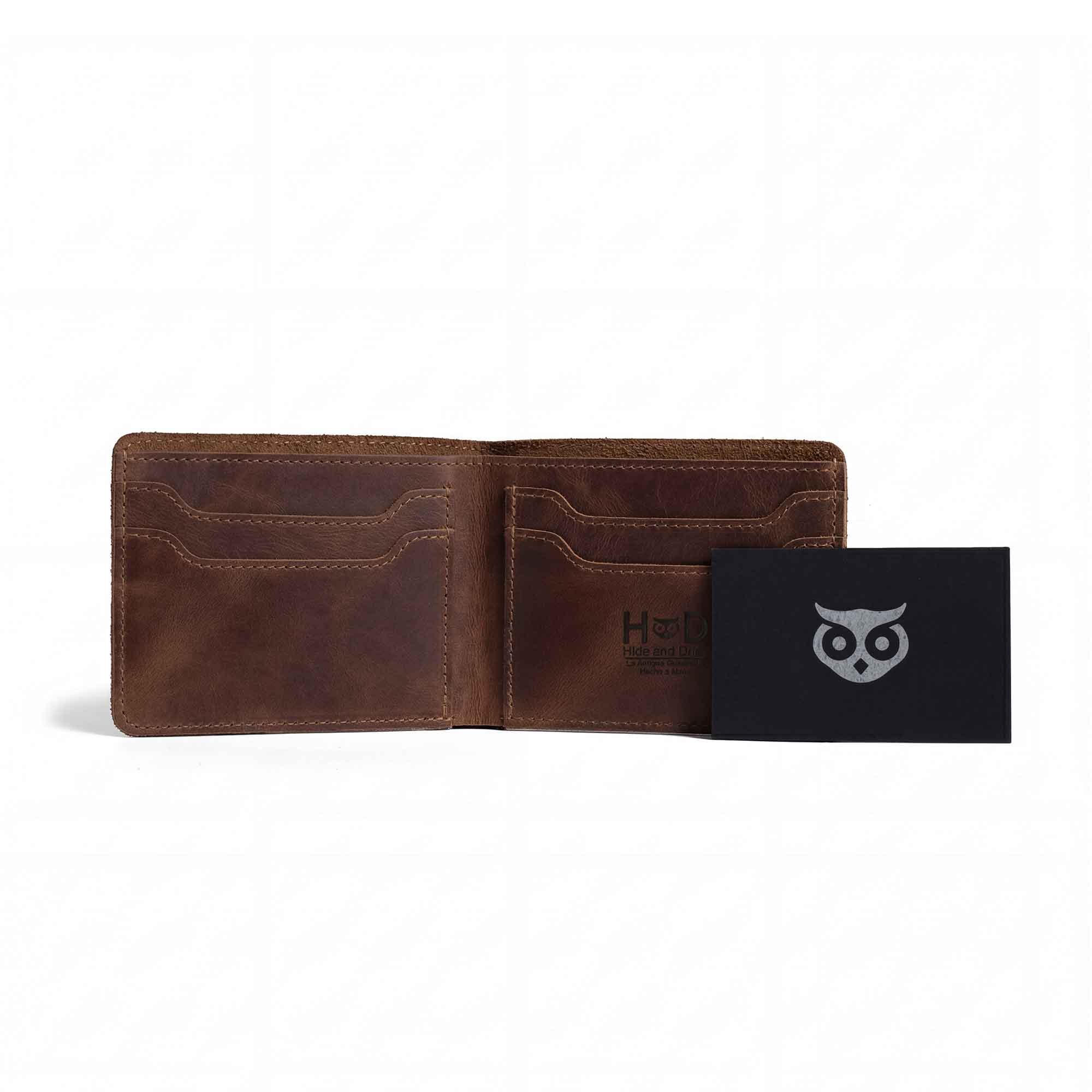 Classic Wallet by Hide & Drink displayed with a business card for scale. This Classic Bifold Wallet is handcrafted from Full Grain Leather, serving as a practical storage case for identification. A great travel accessory, it's designed through artisan small batch production techniques. Hand cut and sewn in La Antigua Guatemala & Oaxaca Mexico.