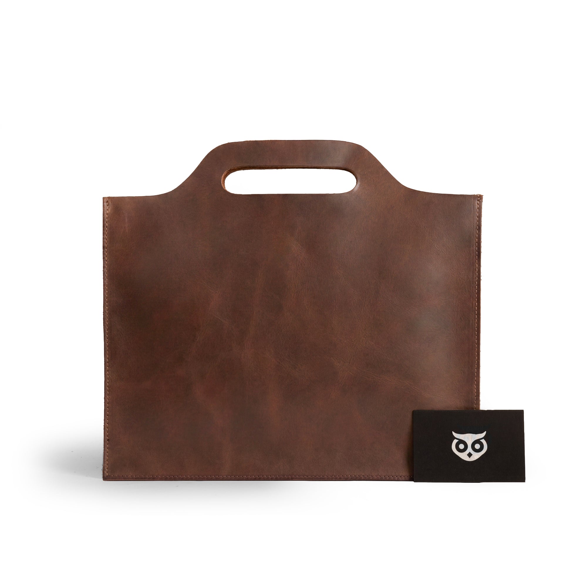 Flat Handbag by Hide & Drink in rich brown full grain leather, showcasing a simple and elegant design, perfect as a minimalist style carry-on bag, thin portfolio, or classic document holder. This travel accessory is crafted with care using small batch production and features hand cut and hand sewn details. Each piece is fire branded, highlighting its artisan quality, all handmade in La Antigua Guatemala & Oaxaca Mexico.