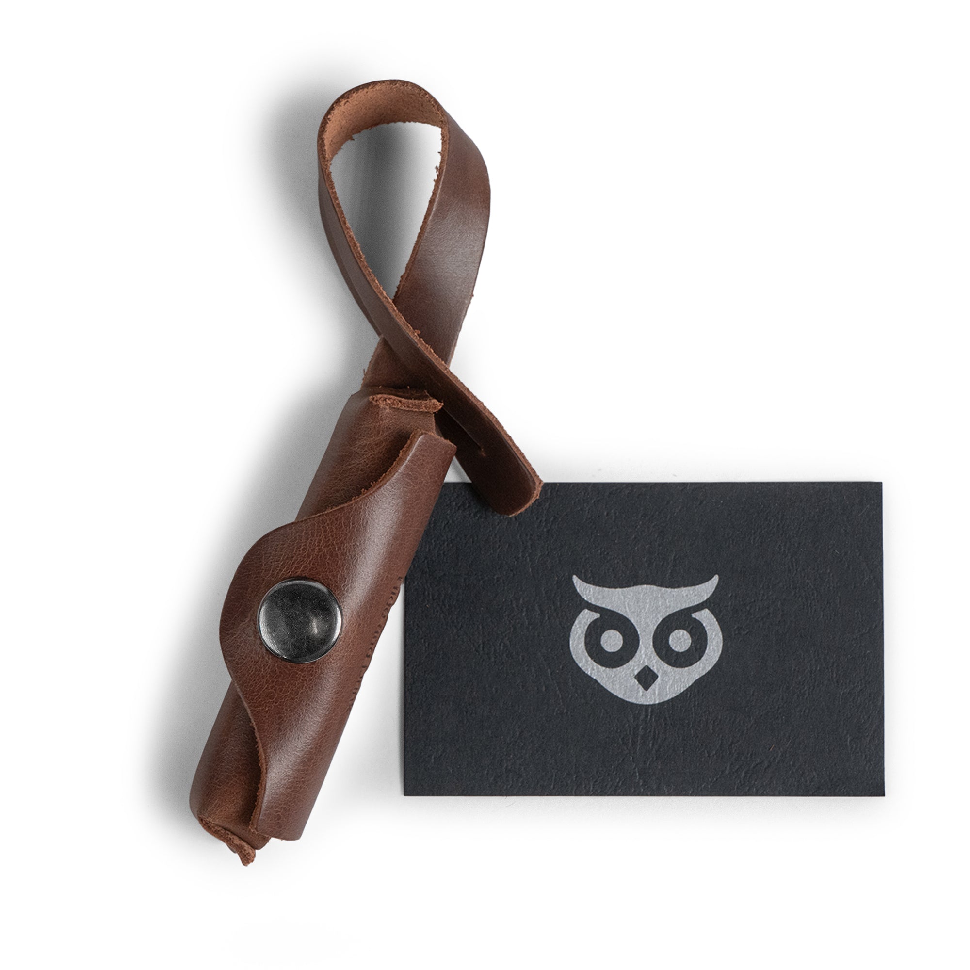 Hide & Drink Lip Balm Holder Bag Charm stylishly arranged with the brand's card, showcasing its artisan design. This charm acts as an excellent Lip Balm Charm for Handbags, Purse Charm for Tote & Backpacks, made from full grain leather with the quality of handmade artistry from La Antigua Guatemala & Oaxaca Mexico.