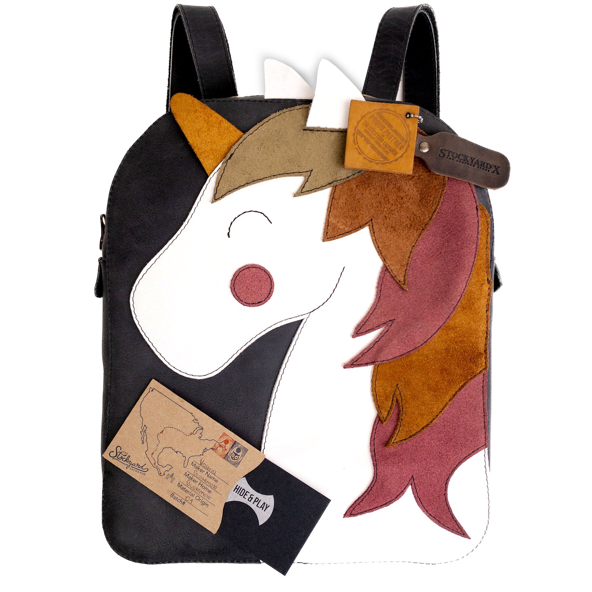 The Hide & Play Daily Backpack with Unicorn Design displayed with an artisan tag, emphasizing its handmade qualities. This full grain leather bag is perfect as a casual messenger bag or travel bag for men and women. Crafted in La Antigua Guatemala, it showcases the beauty of artisan techniques including hand cutting and hand sewing, marking it as a unique product of small batch production.