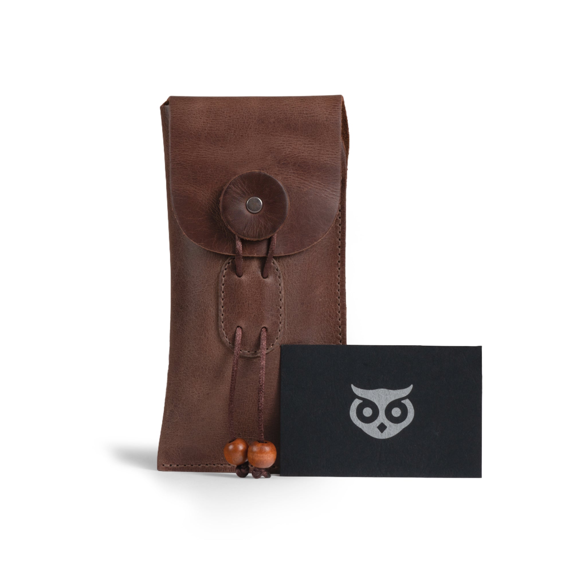 The Slim Eyeglasses Case by Hide & Drink alongside a business card, showcasing its elegant look and artisan brand identity. This full grain leather glasses case is ideal as a sunglasses soft holder, combining practicality with style. Made with care through hand cut and hand sewn methods, it exemplifies handmade quality from La Antigua Guatemala & Oaxaca Mexico.