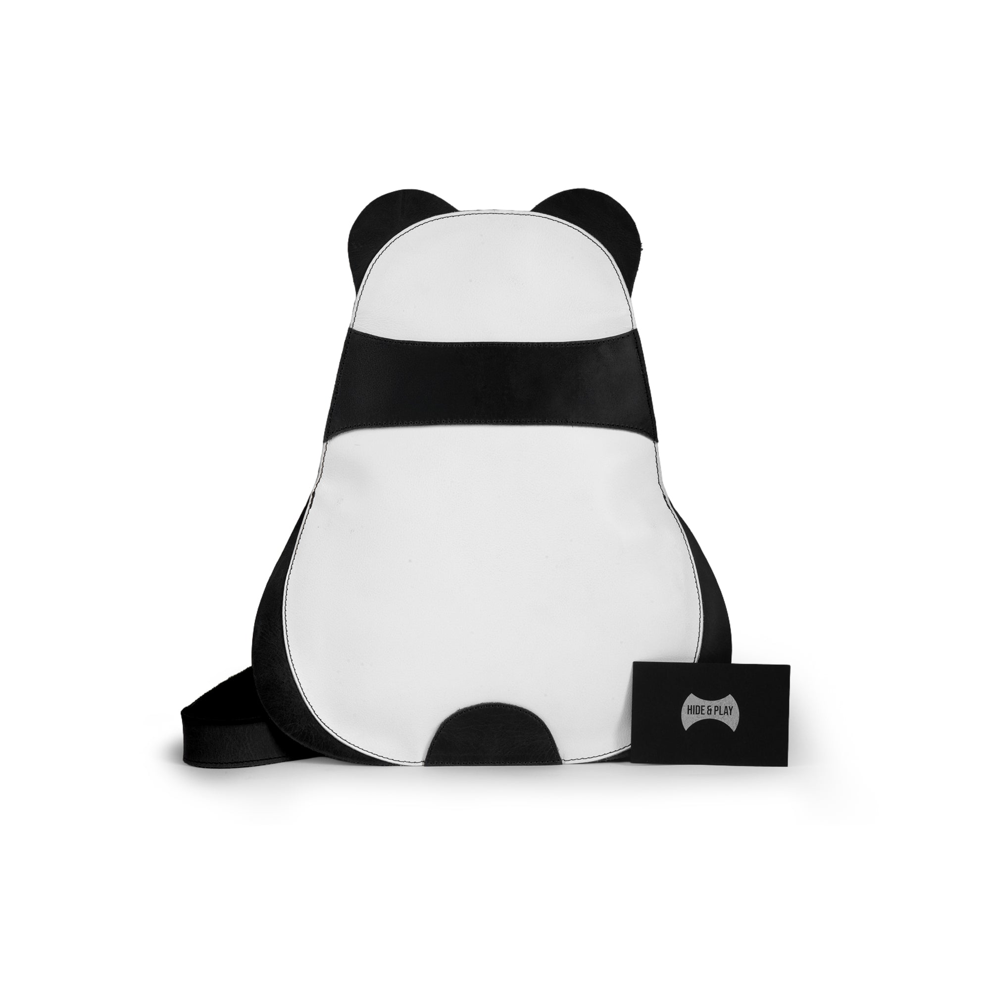 Flat lay of the Panda-Shaped Crossbody Bag by Hide & Play, accompanied by documents and branding tags. This stylish and practical full grain leather bag is part of a unique artisan collection, showcasing small batch production from La Antigua Guatemala & Oaxaca Mexico.