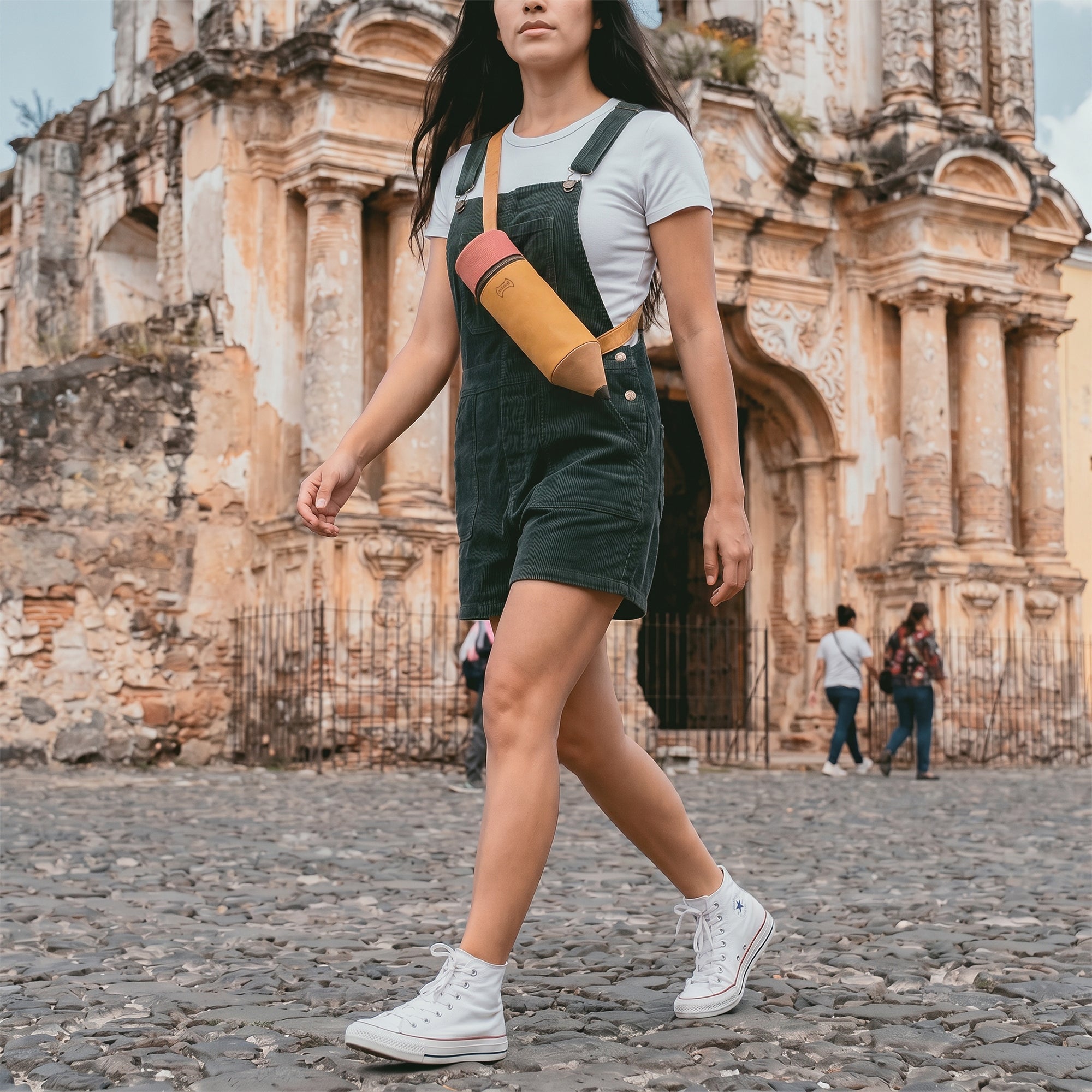 Walking shot of a woman sporting the Pencil-Shaped Crossbody Bag by Hide & Play, showcasing its trendy aesthetic and practical features. This Leather Pencil-Shaped Crossbody Bag is a perfect blend of style and function, ideal for both men and women.