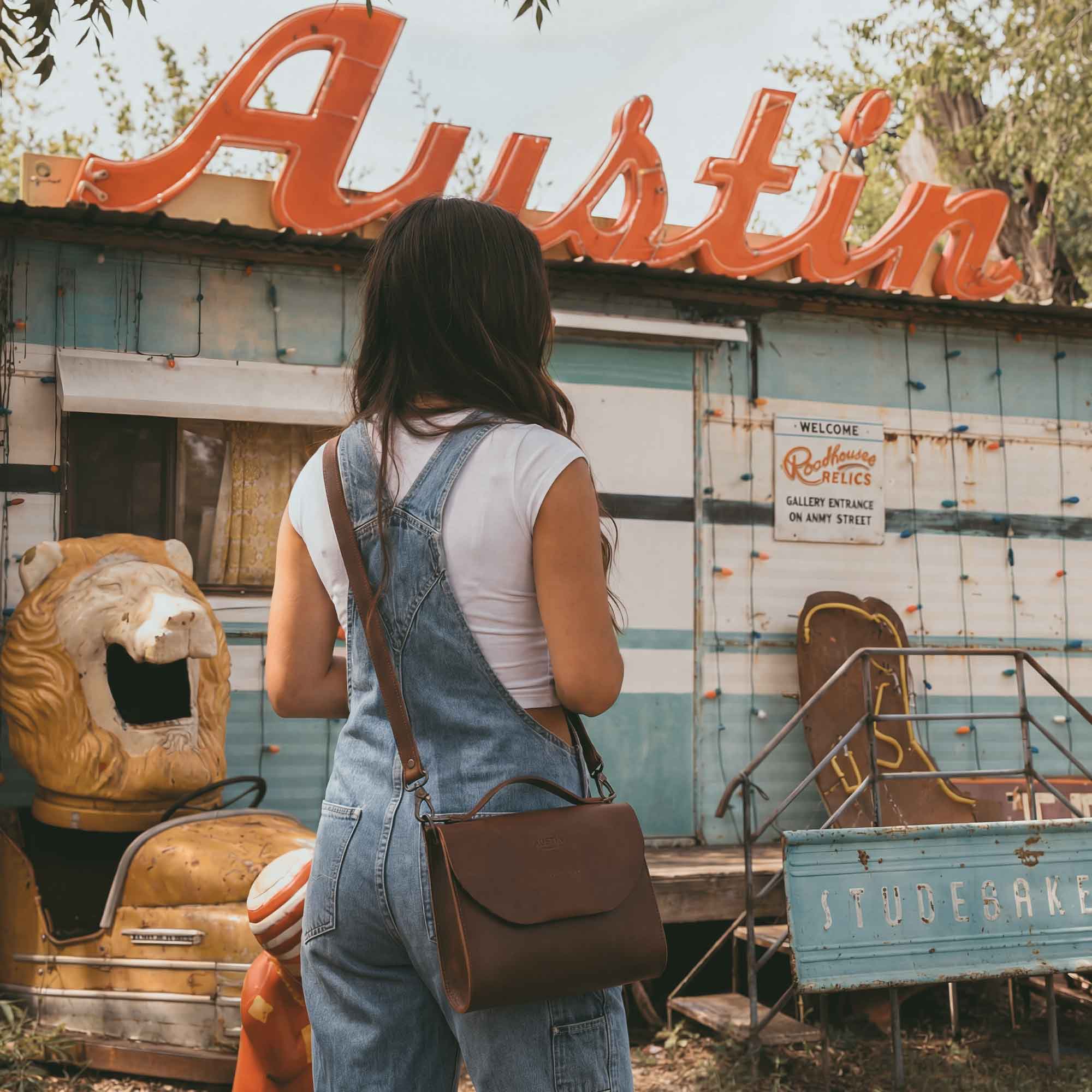 A model wearing The Burnet Crossbody by Austin Genuine, perfectly pairing the full grain leather purse with a casual outfit. This piece embodies artisan craftsmanship with small batch production, hand cut, and hand sewn quality, made in La Antigua Guatemala & Oaxaca Mexico.