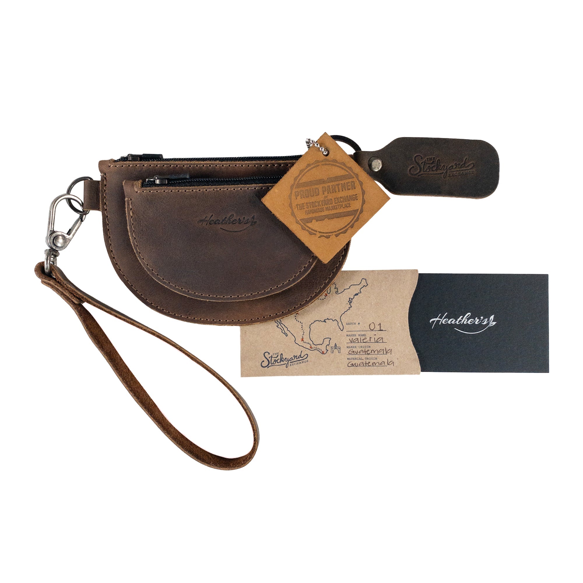 Heather's Semi-Circular Double Wallet presented with care tags and branding, accentuating its quality as a handmade, full grain leather product. This artisan wallet offers excellent functionality as a coin pouch and money holder, reflecting the small batch production ethos.