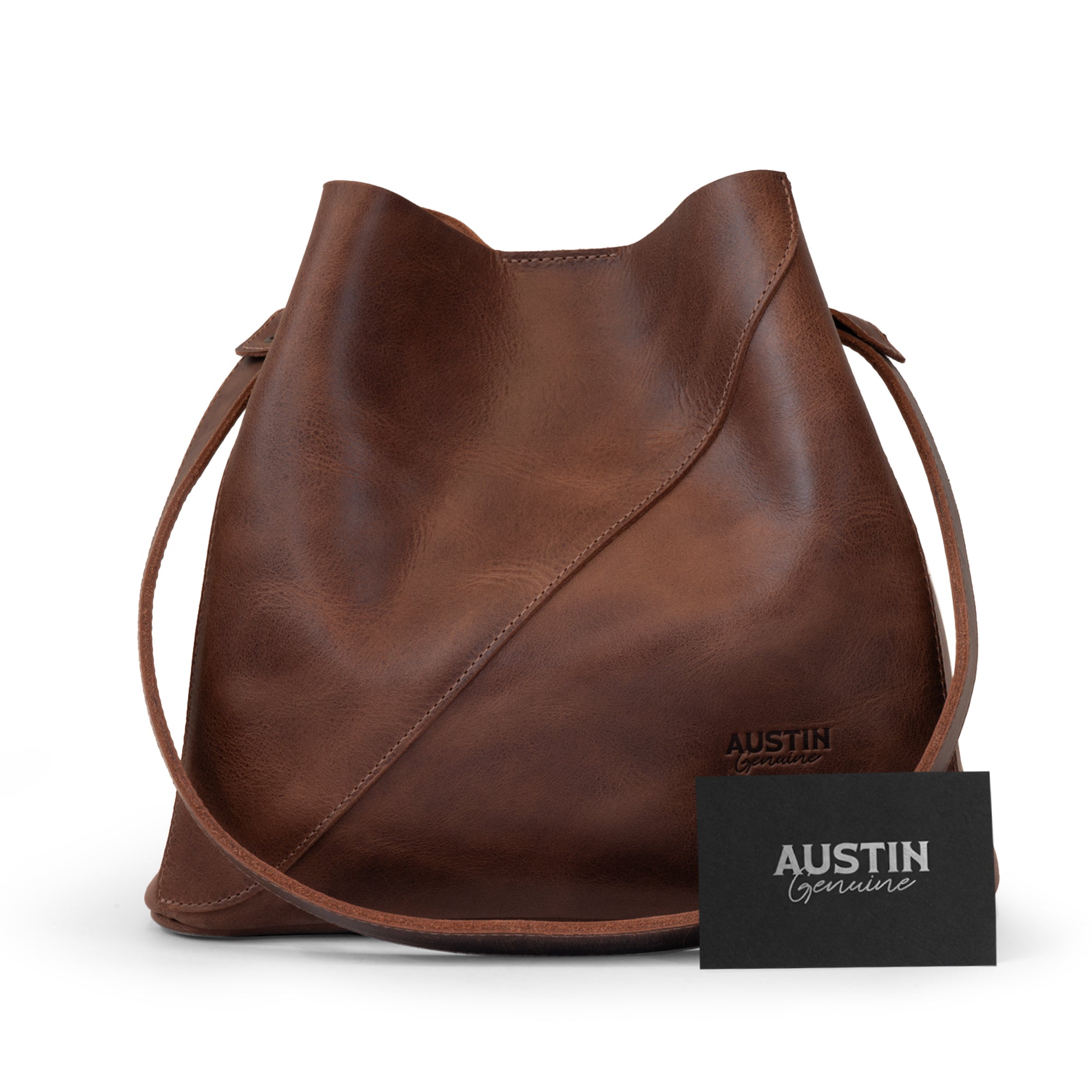 Front view of The Pemberton Shoulder Bag by Austin Genuine with a brand card, emphasizing the artisan quality and full grain leather used in its small batch production.