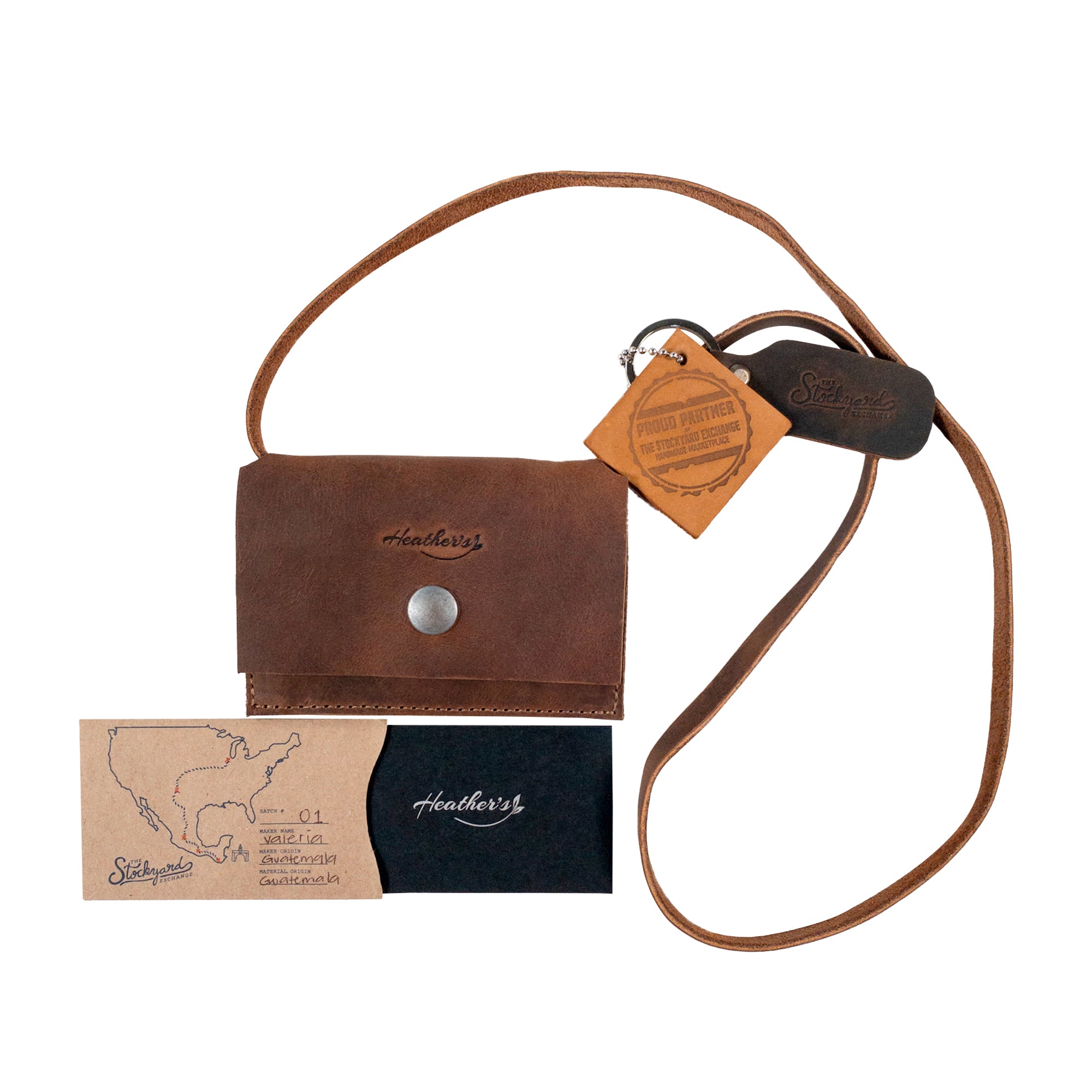 Heather's Mini Purse Wallet in a complete package, featuring artisan tags and showcasing its full grain leather material. This Mini Wallet Purse with Strap serves as a stylish card holder and money organizer, highlighting small batch production, hand cut, hand sewn, and fire branded craftsmanship, representing artisan work from La Antigua Guatemala.