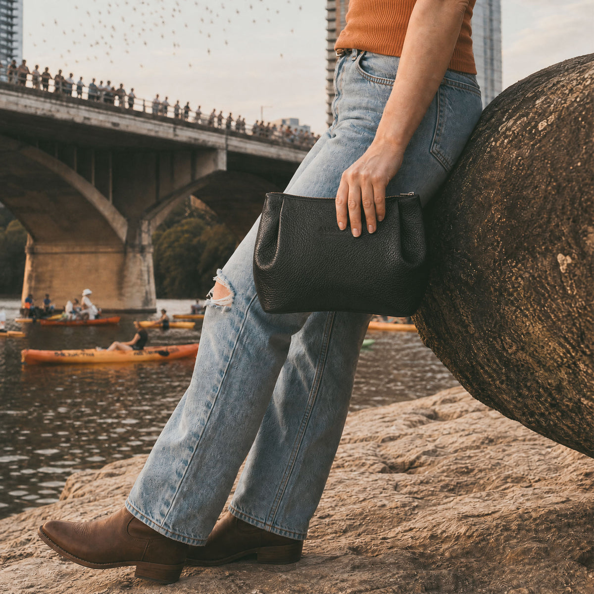 Austin Genuine The Kinney Beauty Bag used as an everyday beauty pouch in a city park, featuring The Kinney Beauty Bag Full Grain Leather, StockyardX, Small Batch Production, Hand Cut, Hand Sewn, Fire Branded, Artisan, Handmade in La Antigua Guatemala & Oaxaca Mexico craftsmanship.