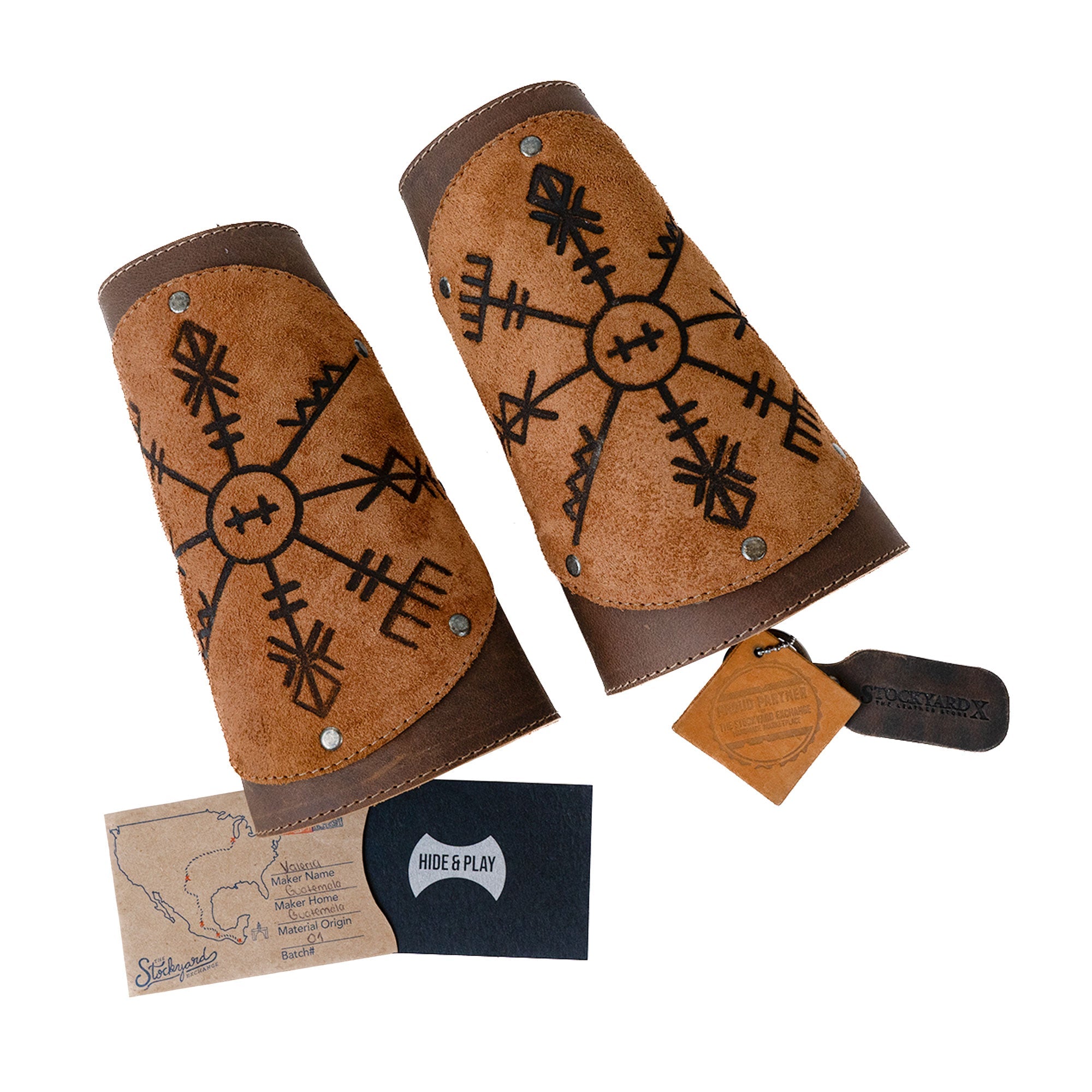 All components of Viking Bracers by Hide & Play displayed, including the set of 2 Viking Style Bracers and an authenticity card. These arm protectors for costume are made from high-quality full grain leather, embodying small batch production and artisan skills from La Antigua Guatemala & Oaxaca Mexico.