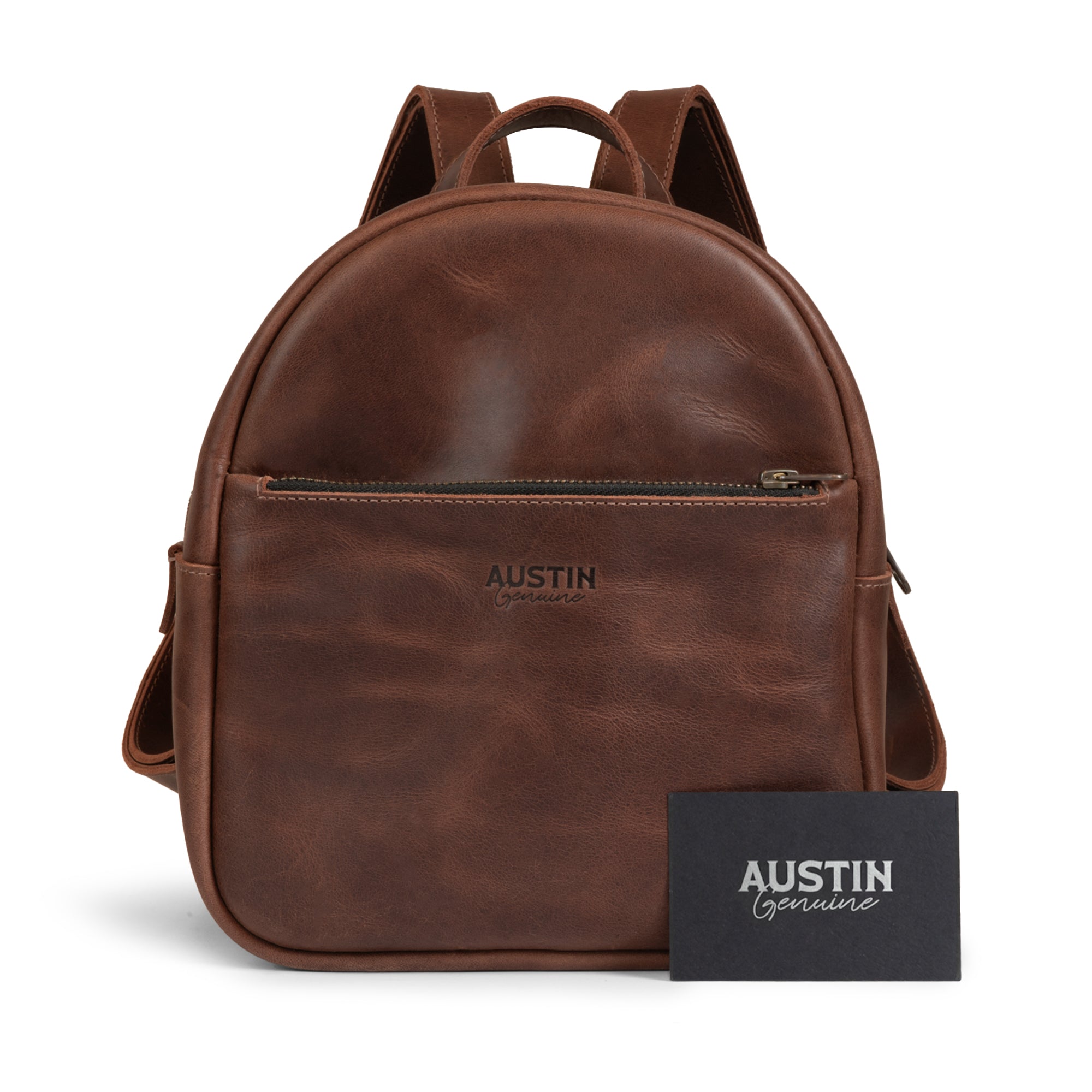 The front view of The Holly Mini Backpack by Austin Genuine alongside a card, showcasing its design and quality full grain leather, complemented with tags like Full Grain Leather, StockyardX, Small Batch Production, Hand Cut, Hand Sewn, Fire Branded, Artisan, Handmade in La Antigua Guatemala & Oaxaca Mexico.