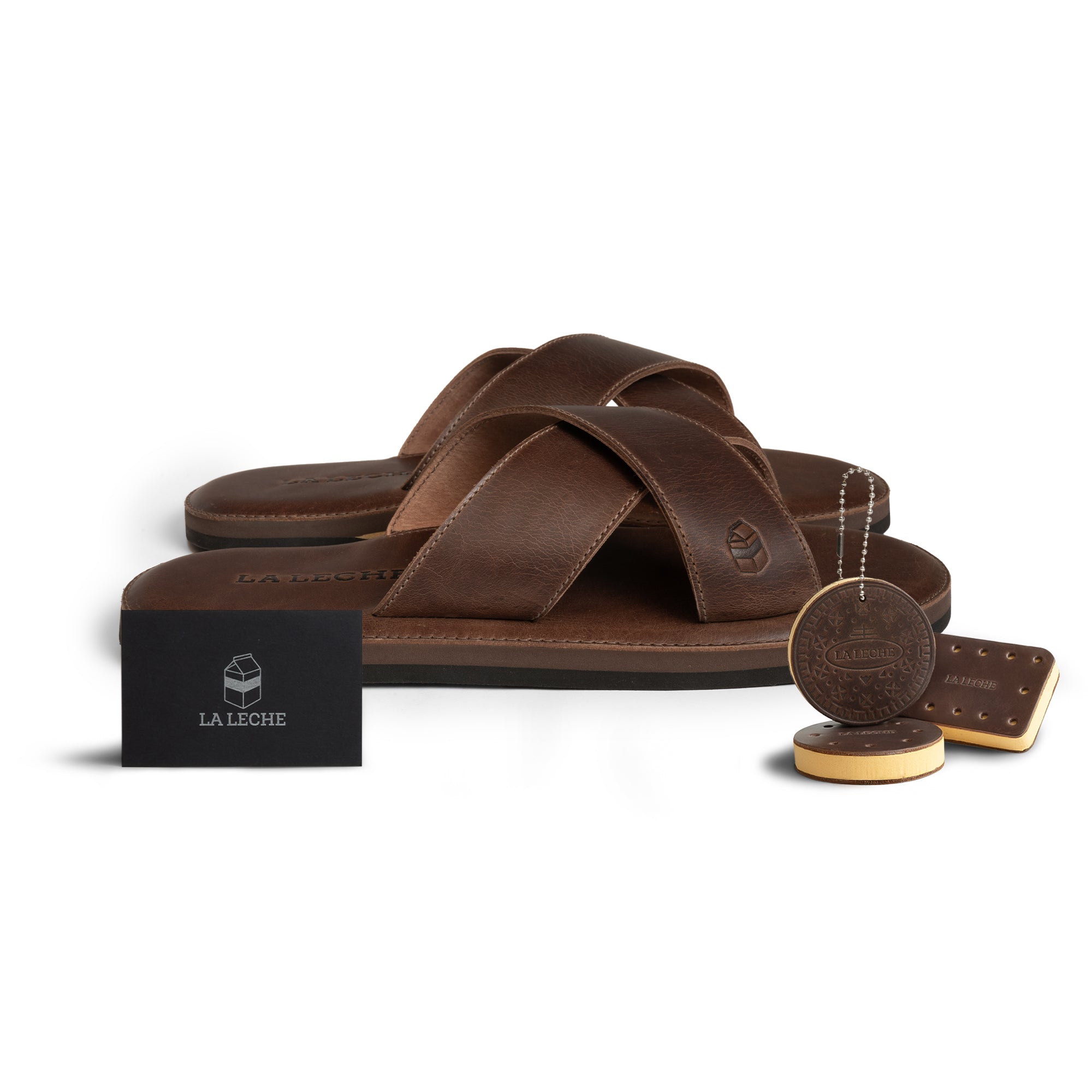 A beautifully arranged display featuring The Wanderer Arch Comfort Sandals along with artisan tags to highlight the craftsmanship by La Leche. These Slide Sandals with soft cushion for arch support are perfect for indoor and outdoor wear, handmade using Full Grain Leather and Memory Foam, showcasing their artisanal quality.