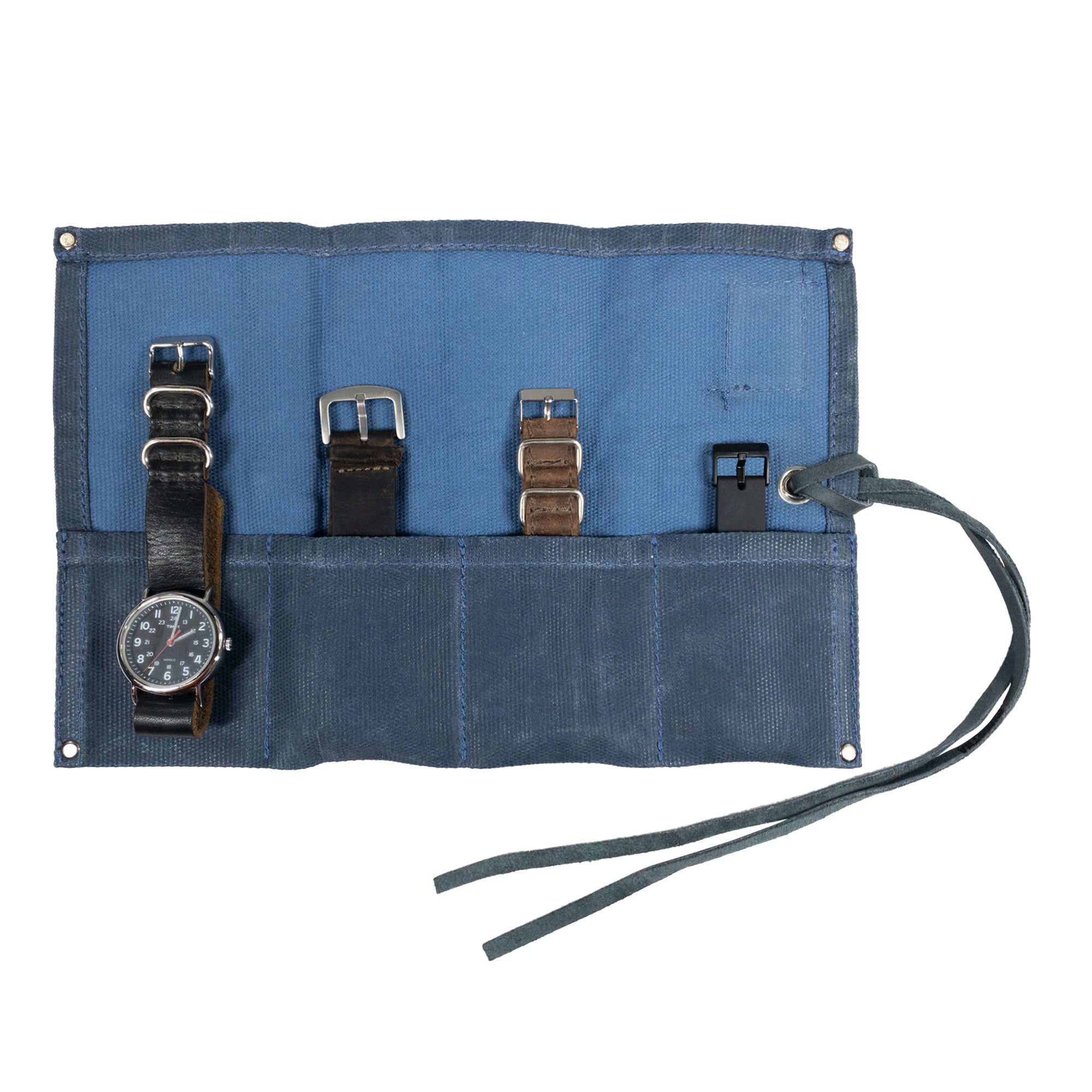 The Waxed Canvas Watch Roll in blue fabric by Hide & Drink, holding four watches in a stylish manner. This handmade organizer excels in both aesthetics and function.