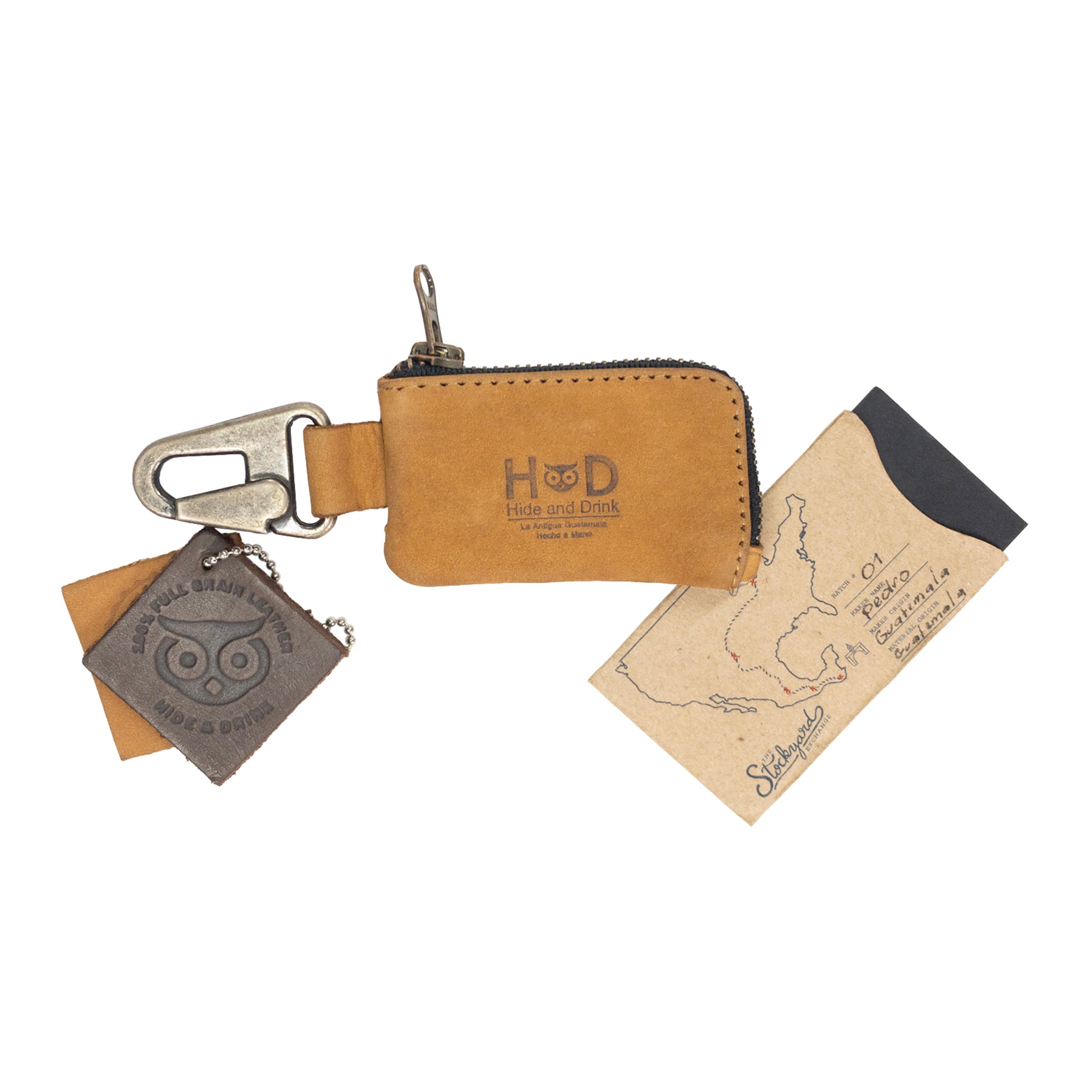 The Hide & Drink Car Key Holder resting elegantly alongside cash and keys, designed for practicality with a nickel metal clasp. Perfect for organizing headphone cables and flash drives, artisan made in La Antigua Guatemala & Oaxaca Mexico.