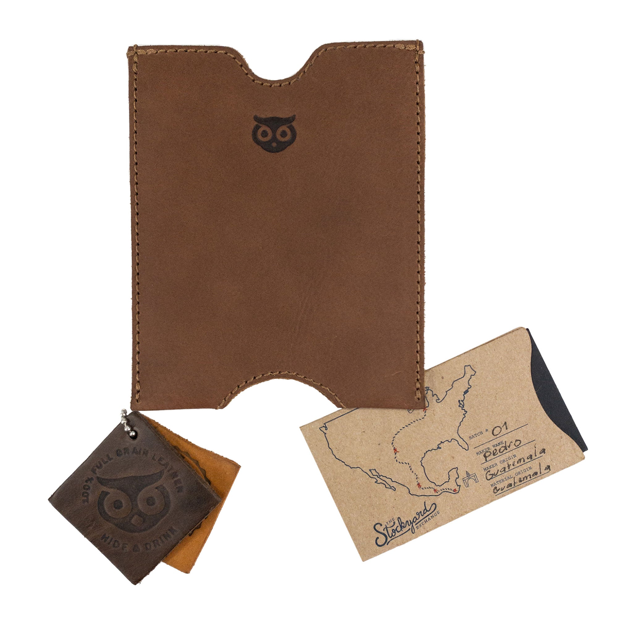 Hide & Drink Passport Sleeve displayed alongside leather tags and travel notes, emphasizing its artisan quality. This full grain leather travel passport pocket sleeve enhances your travel style. Features tags: Travel Passport Pocket Sleeve, Full Grain Leather, StockyardX, Small Batch Production, Hand Cut, Hand Sewn, Fire Branded, Artisan, Handmade in La Antigua Guatemala & Oaxaca Mexico.