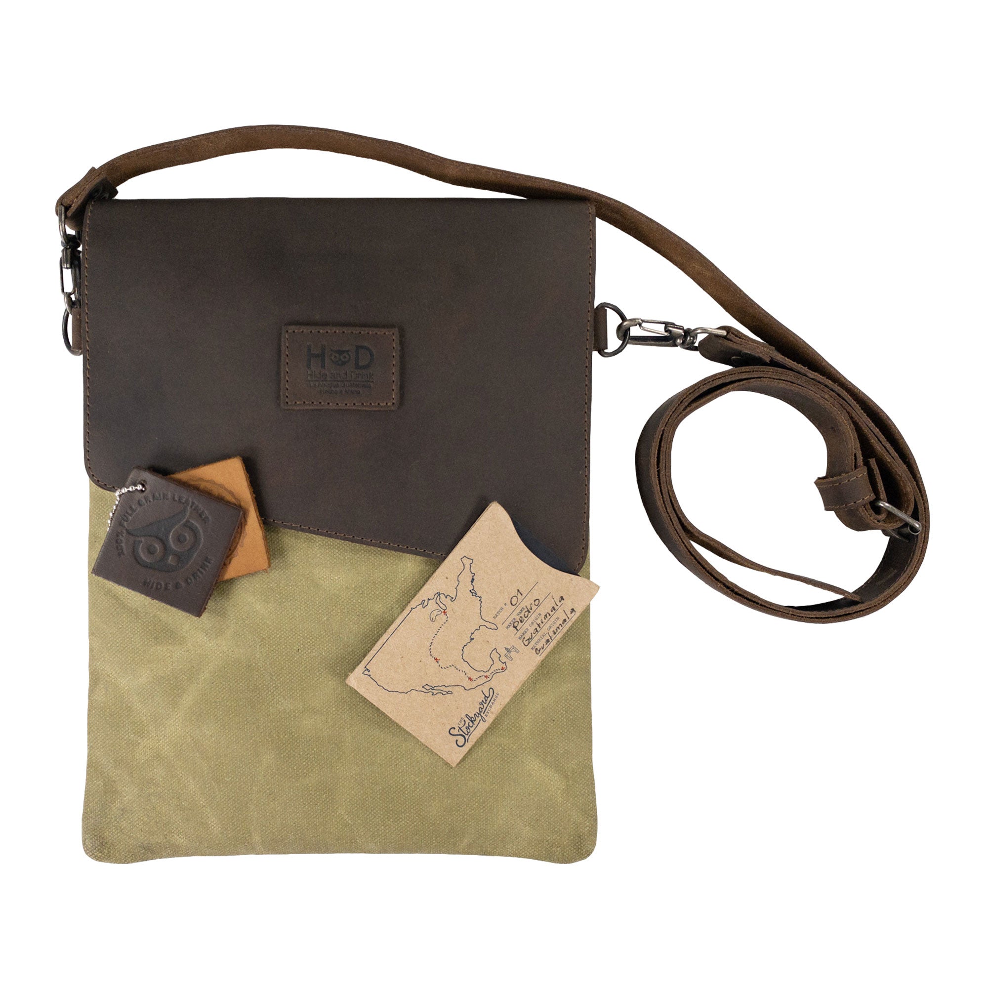 Hide & Drink Crossbody Bag displayed with its dimensions for reference, emphasizing its practical size. This Crossbody Bag with Adjustable Shoulder Strap is a Unisex Messenger Bag crafted from exceptional Full Grain Leather & Waxed Canvas, featuring small batch production, hand cut, hand sewn, fire branded techniques from artisans in La Antigua Guatemala & Oaxaca Mexico.