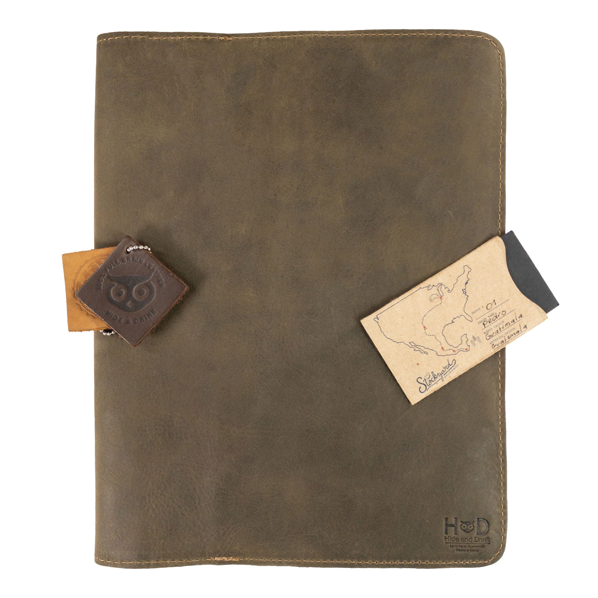 The Journal Cover for (8.5 x 11 in.) Moleskine Cahier XXL from Hide & Drink, displayed casually to highlight its rich leather texture and functional design. Perfect for any writing enthusiast, made with care in La Antigua Guatemala & Oaxaca Mexico.