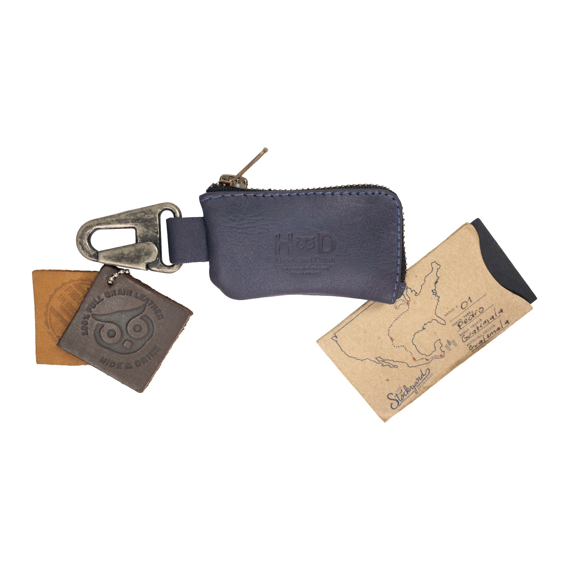 Hide & Drink Car Key Holder displayed with packaging, showcasing its craftsmanship as a Cash Zipper Case with a Nickel Metal Clasp, perfect for holding headphone cables and memory cards, made from premium full grain leather. StockyardX, Small Batch Production, Hand Cut, Hand Sewn, Fire Branded, Artisan, Handmade in La Antigua Guatemala & Oaxaca Mexico.