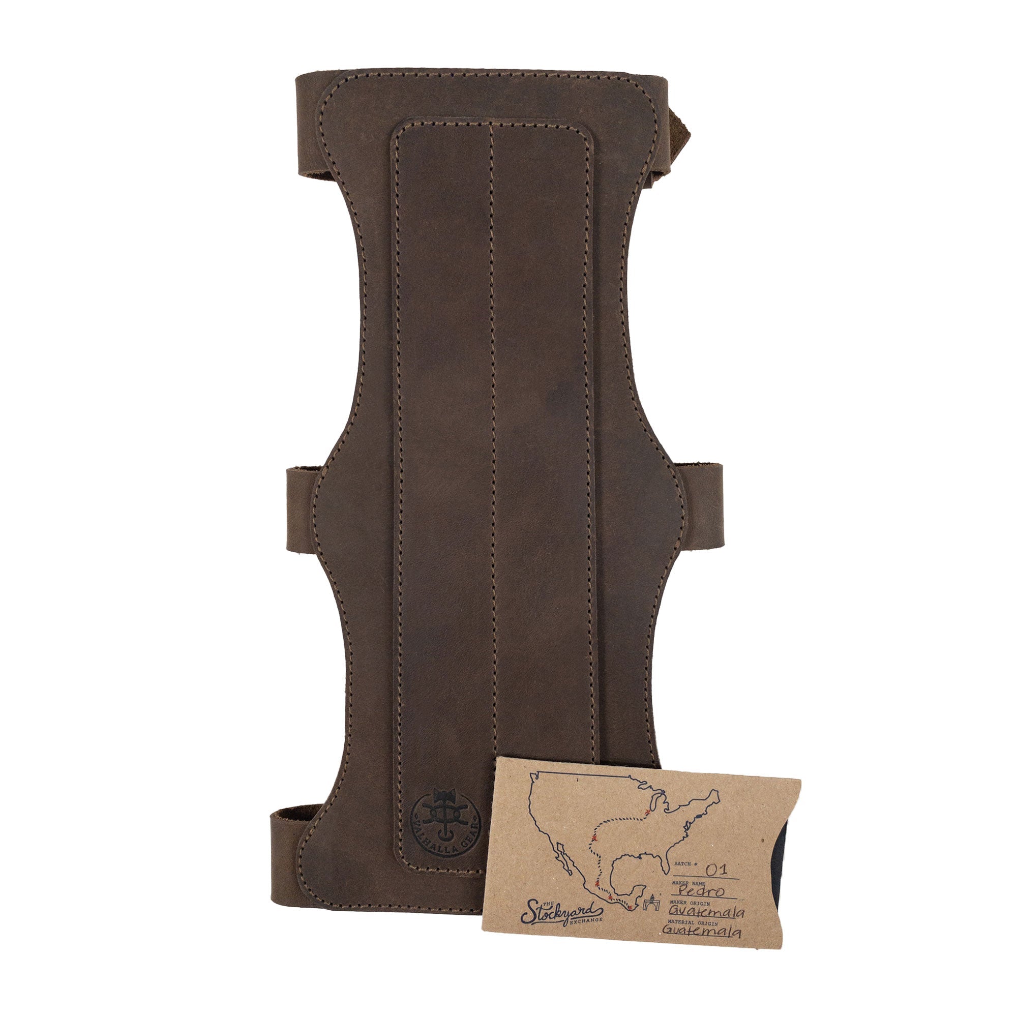 The 3-Buckle Archery Bracer from Valhalla Gear alongside its authenticity card. This artisan piece made from full grain leather represents small batch production in La Antigua Guatemala, designed for archery with adjustable straps for a personalized fit.