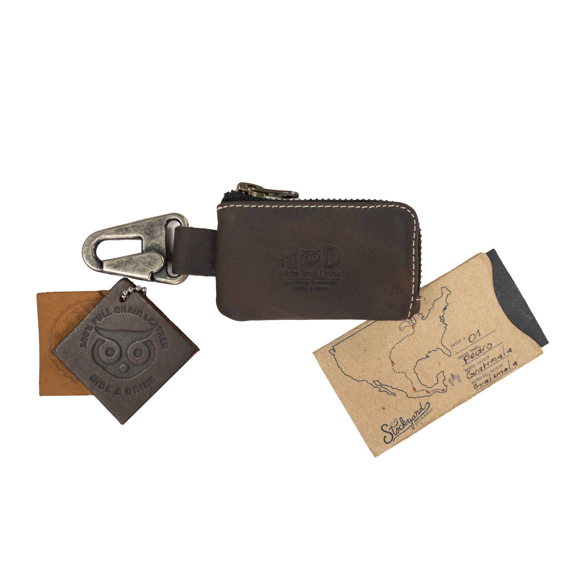 Close-up view of the Car Key Holder by Hide & Drink showcasing the quality craftsmanship in its design. This accessory effectively holds keys, cash, and serves as a case for Headphone and charging Cables, Memory Cards, and Flash Drives. Made from durable Full Grain Leather with a Nickel Metal Clasp, exemplifying artisan quality from Small Batch Production in La Antigua Guatemala & Oaxaca Mexico.