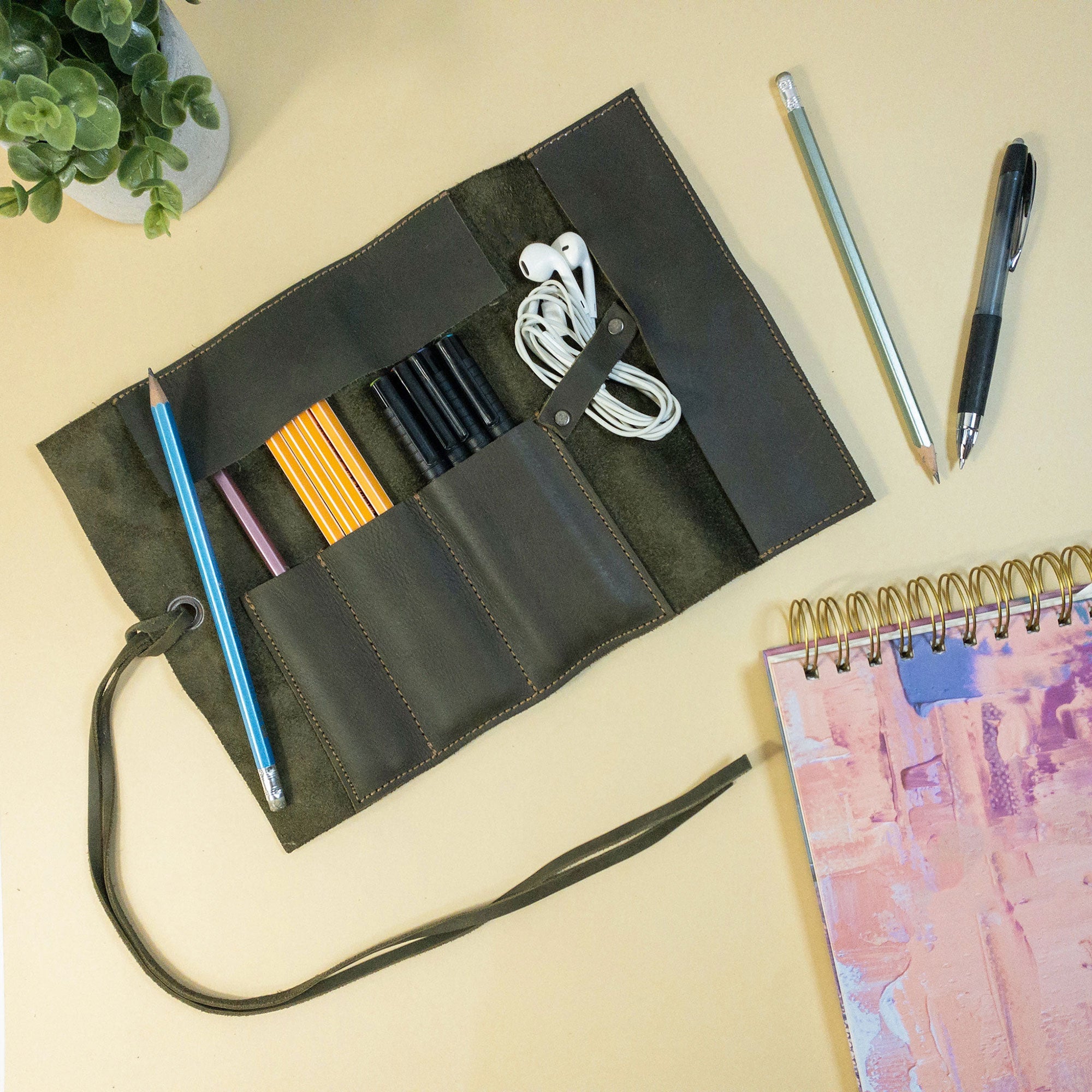 Hide & Drink Multi Purpose Pencil Roll in its closed form, highlighting the quality craftsmanship of full grain leather. This artisan-made rustic storage wrap is perfect for organizing work tools and crafting essentials, made in La Antigua Guatemala & Oaxaca Mexico.