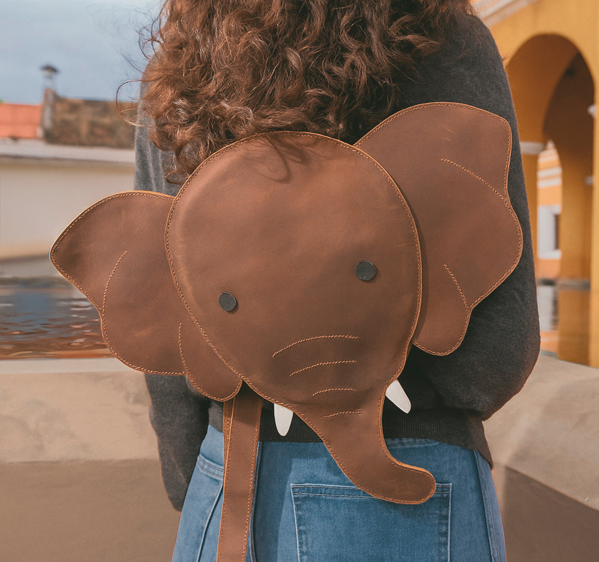 Unique Elephant-Shaped Backpack by Hide & Play, showcasing a playful elephant silhouette. This versatile Messenger Bag is crafted from Full Grain Leather, perfect as a Travel Bag for Men and Women. StockyardX emphasizes artisan quality through handmade processes in La Antigua Guatemala, ensuring durability and style.