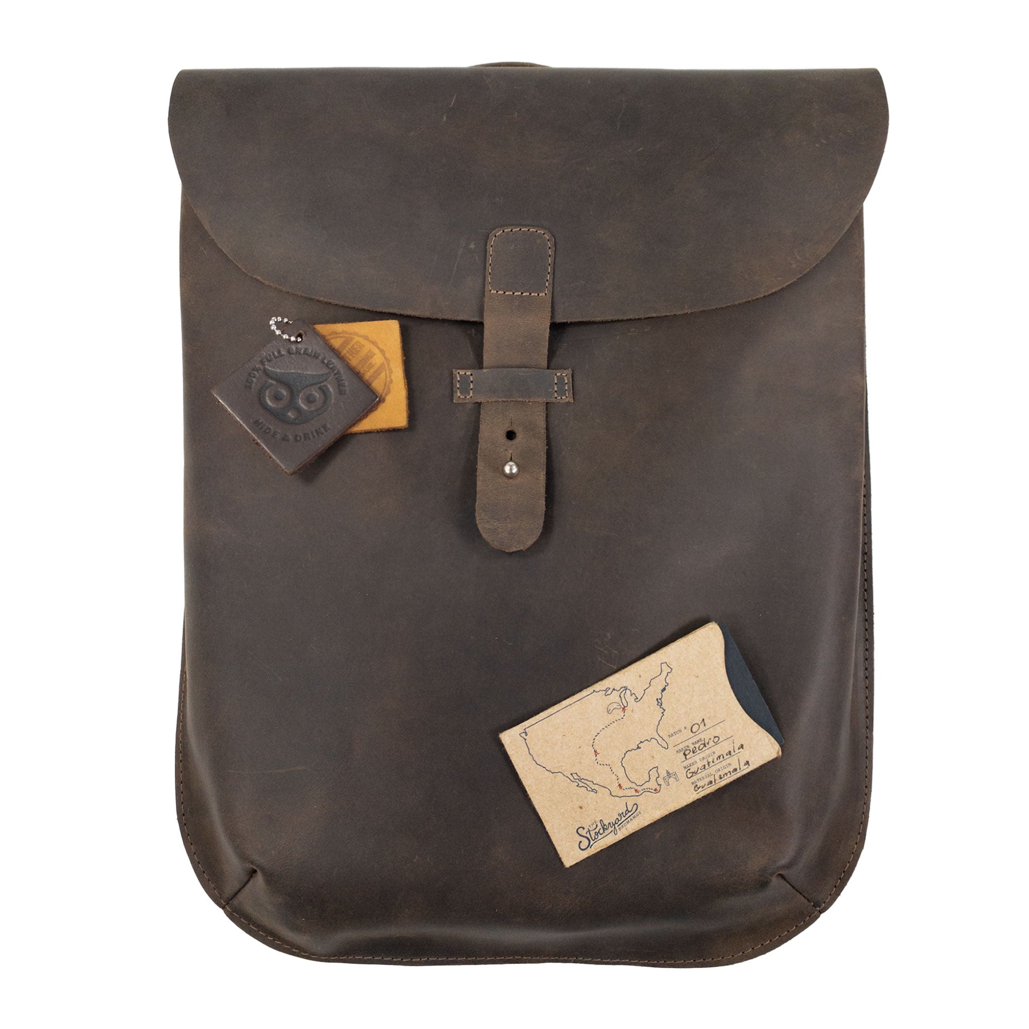 Front view of Hide & Drink's Rounded Laptop Backpack with Adjustable Straps adorned with tags. This full grain leather backpack is both a portable case and a travel accessory, representing artisan craftsmanship from La Antigua Guatemala & Oaxaca Mexico, made with care in small batch production.
