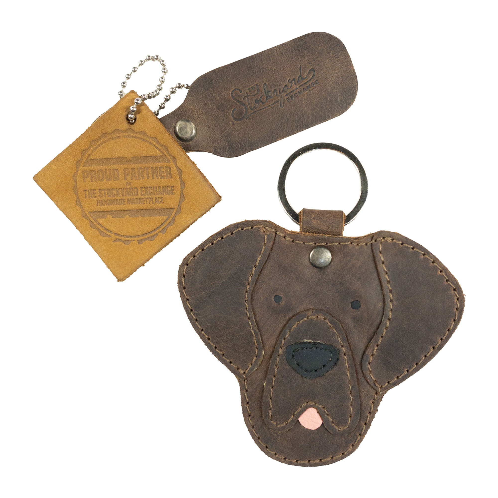 Labrador Dog Critter Keychain by Taco Dog displayed with its tag, emphasizing its artisan nature. Made from Full Grain Leather, it features handcrafted detailing, fire branded elements, and is a unique piece from small batch production in La Antigua Guatemala.