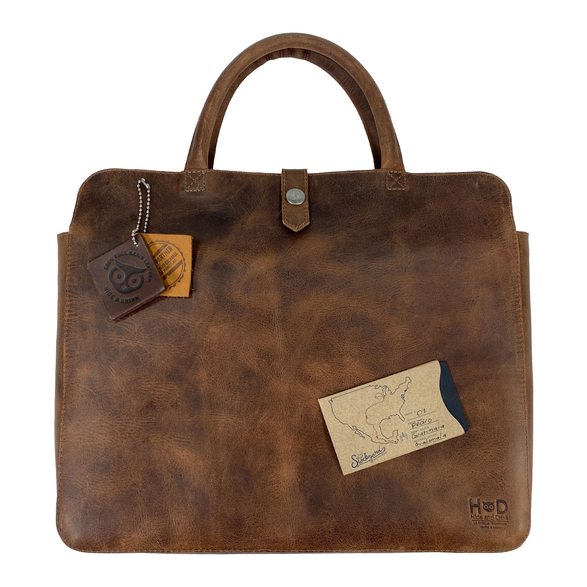 Vintage Portfolio with Snap for 13" MacBook Air by Hide & Drink, featuring a charm and card to emphasize its artisanal background. Made from rich Full Grain Leather through Small Batch Production methods, this Artisan piece showcases hand-cut, hand-sewn, and fire branded details from La Antigua Guatemala & Oaxaca Mexico.