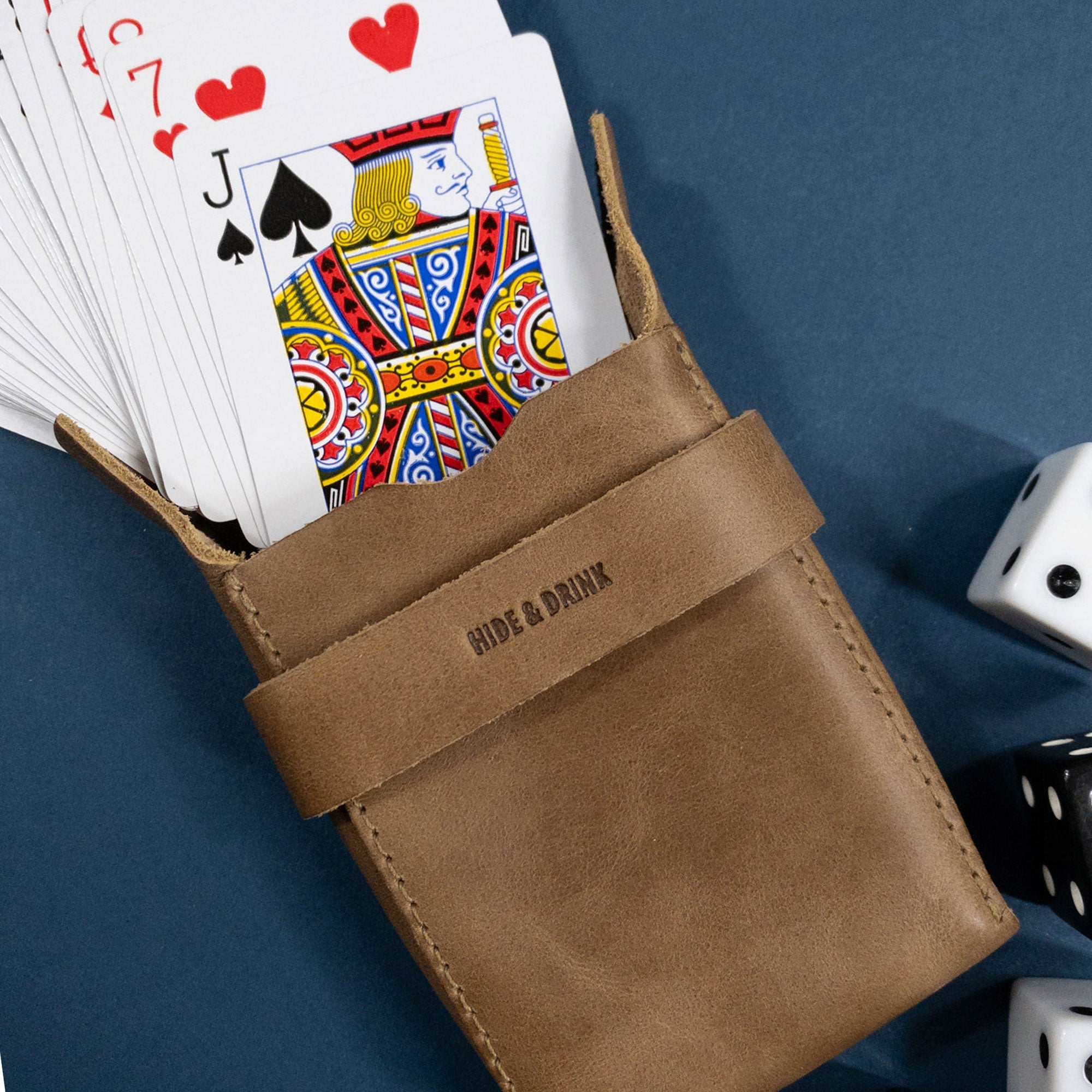 Hide & Drink's brown Playing Card Case displayed with an Ace of spades card for reference. This classic case for playing cards (not included) provides secure storage in a stylish design. Made from premium full grain leather, it emphasizes artisan craftsmanship from StockyardX.
