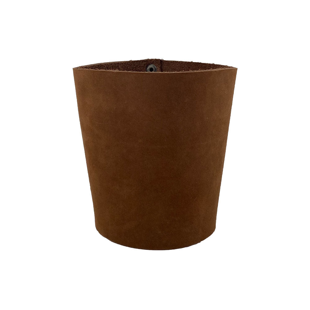 A beautiful brown leather Pint Sleeve by Hide & Drink, showcasing its unique texture and durable construction. This artisan product offers natural temperature control for drinks, and the addition of brass metal rivets enhances its classic design, handmade in La Antigua Guatemala & Oaxaca Mexico.