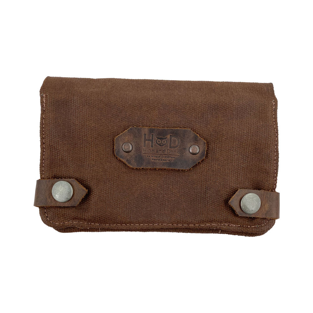 Front view of the dark brown Hide & Drink Tobacco Pouch Waxed Canvas with snap closures. This classic storage solution is handcrafted, making it a must-have for tobacco and field notes, showcasing the artisanal quality from La Antigua Guatemala.