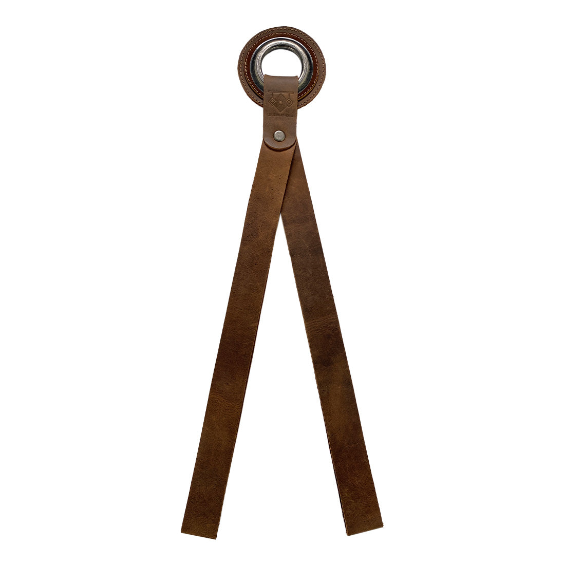 Close-up view of a handcrafted Book Wall Hanger from Leather At Home, made of robust full grain leather, embodying artisan craftsmanship. This wall organizer is great for storing books, comics, and magazines with style. Designed for readers, it reflects small batch production and fire-branded artistry from La Antigua Guatemala & Oaxaca Mexico.