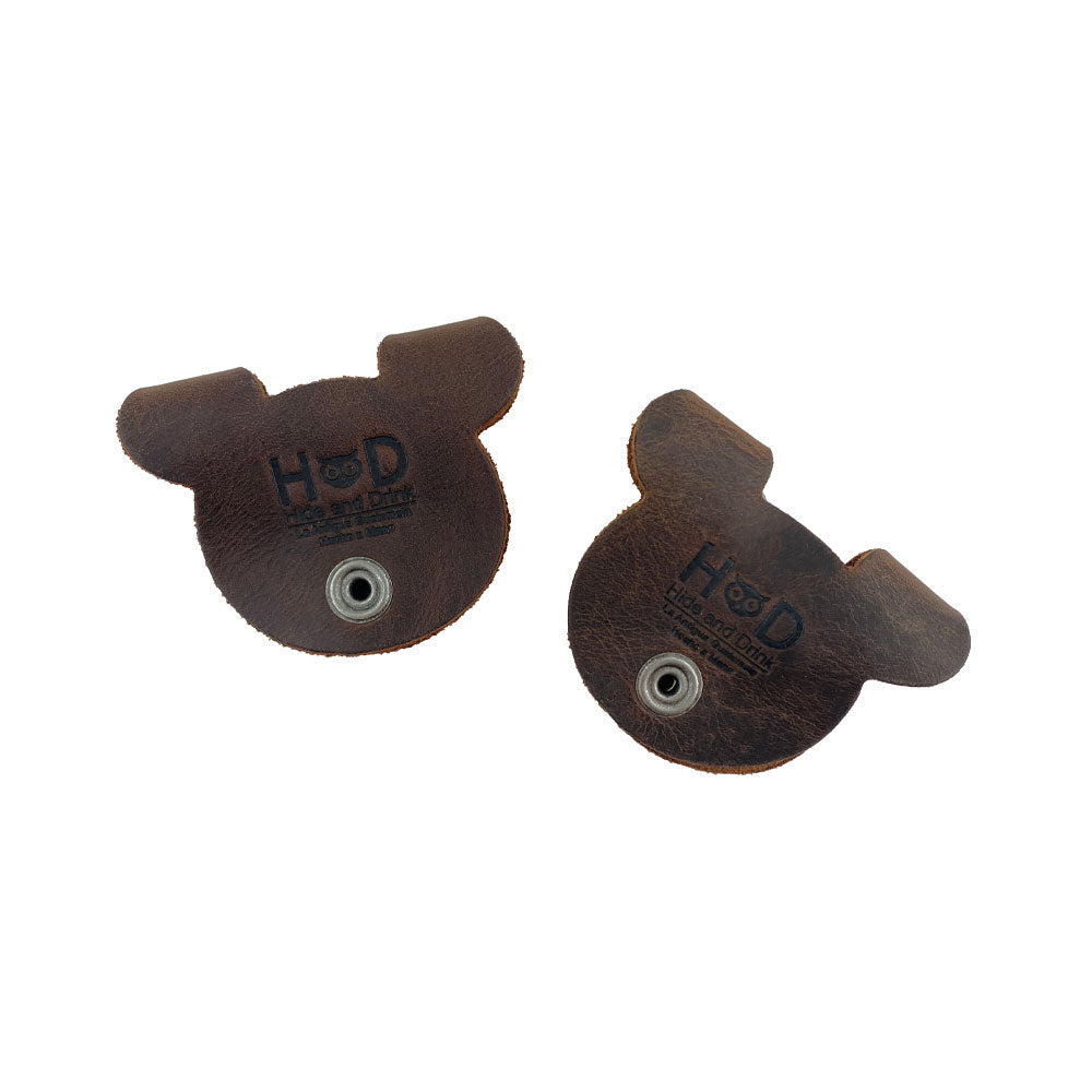Back view of darker Bear Shaped Cord Keepers (Cord Clam) by Hide & Drink, showcasing fire branded details and the quality Full Grain Leather. Artisan crafted in La Antigua Guatemala & Oaxaca Mexico, representing small batch production.