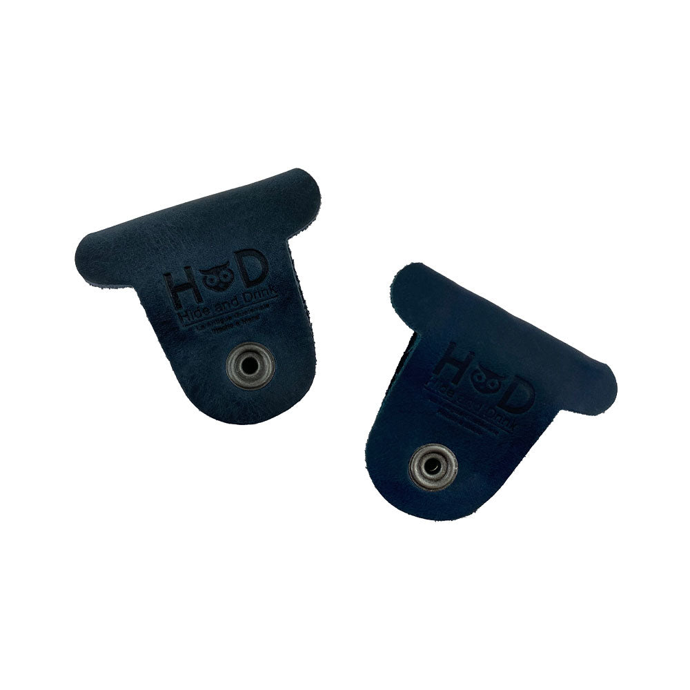Two navy blue Dog Shaped Cord Keepers featuring the Hide & Drink logo, made of high-quality Full Grain Leather for practical use. Dog Shaped Cord Keeper (Cord Clam) 2-Pack, Full Grain Leather, StockyardX, Small Batch Production, Hand Cut, Hand Sewn, Fire Branded, Artisan, Handmade in La Antigua Guatemala & Oaxaca Mexico.