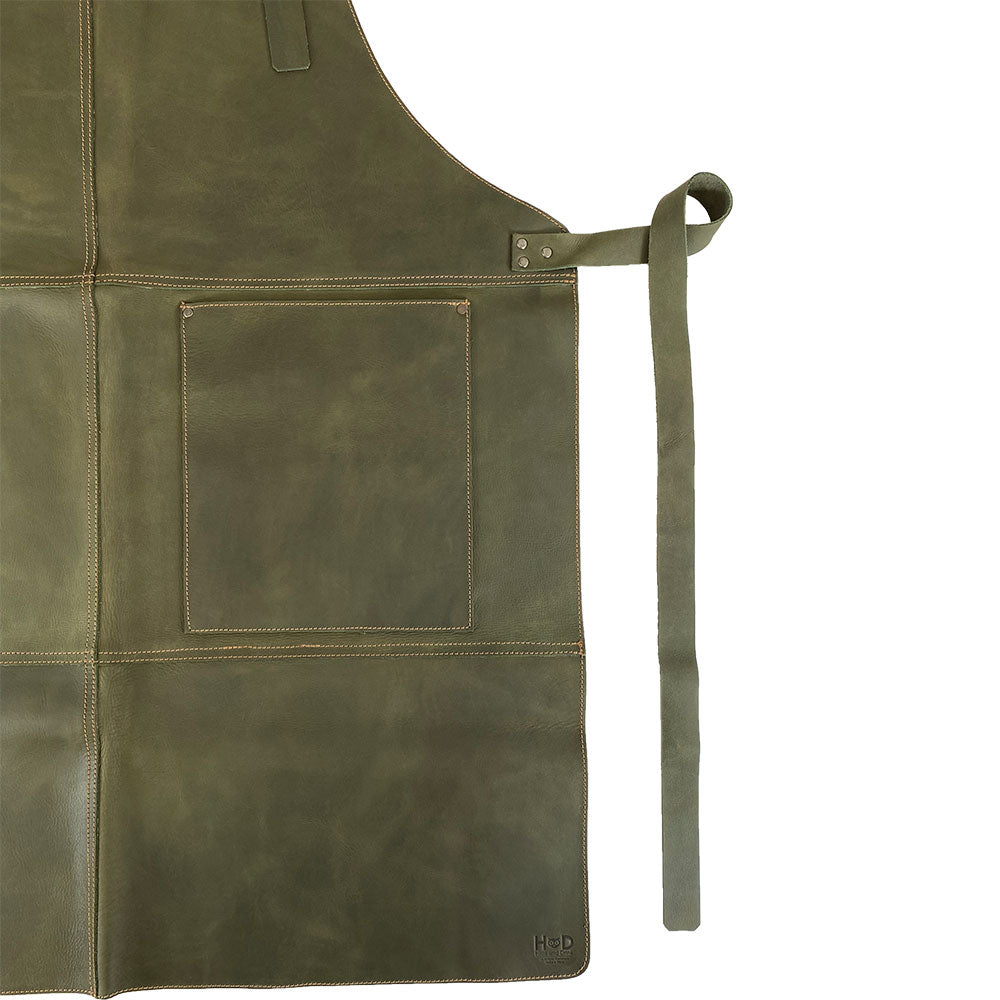 Close-up of the Hide & Drink Leather Apron in green, highlighting its durable construction and functional pockets made from full grain leather. This Leather Apron is artisan-made in Guatemala.