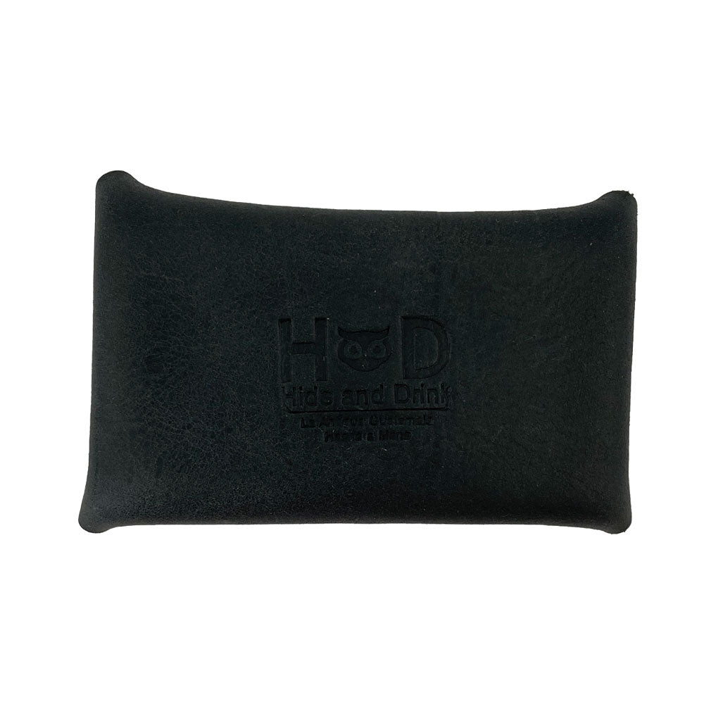 The Hide & Drink Envelope Coin Case in black features a rustic leather branding, emphasizing its quality. This artisan wallet is made from full grain leather and handcrafted with care in La Antigua Guatemala & Oaxaca Mexico.