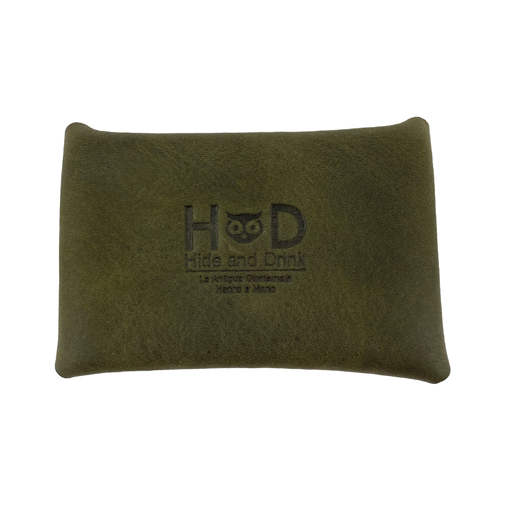 The Hide & Drink Envelope Coin Case in olive green featuring a branded logo, emphasizing its artisan craftsmanship. Made from full grain leather, this small batch production case is handcrafted in La Antigua Guatemala & Oaxaca Mexico.