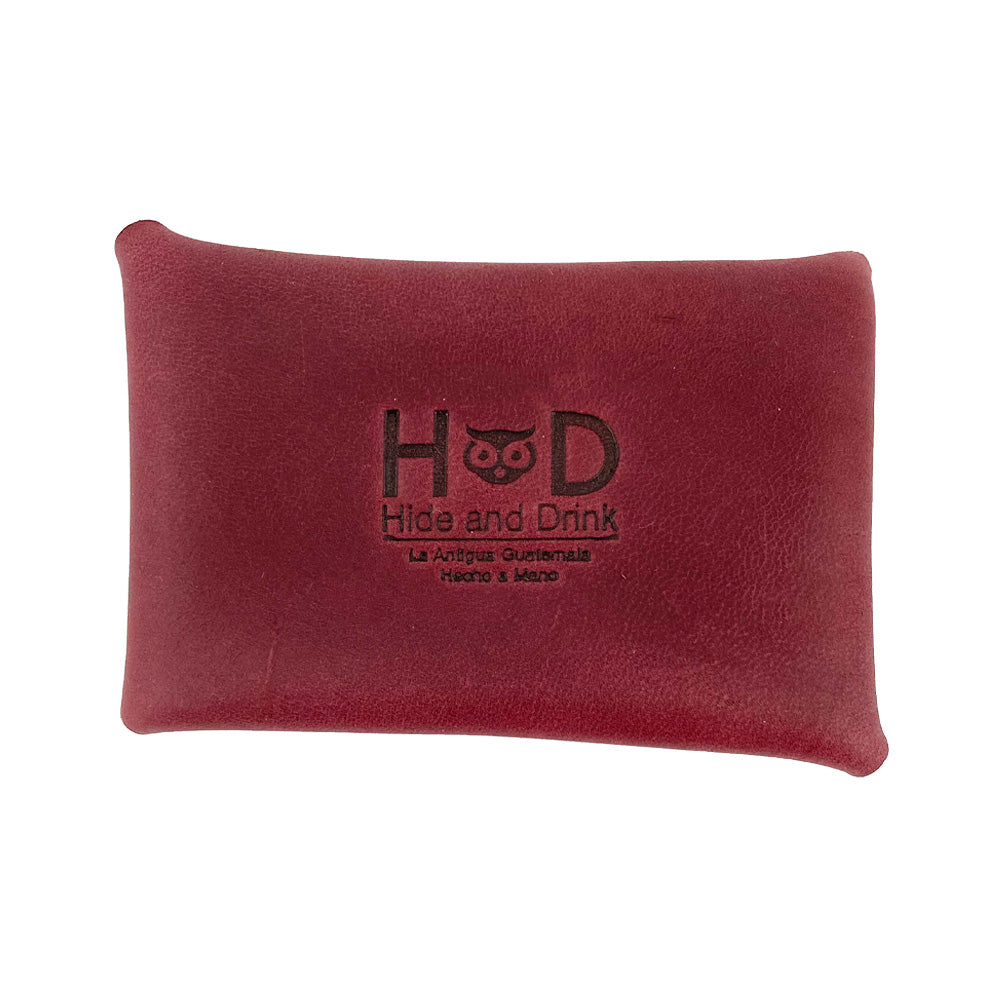 The burgundy Hide & Drink Envelope Coin Case featuring a branded logo, emphasizing quality craftsmanship. Handcrafted from full grain leather, this rustic leather case is made in La Antigua Guatemala & Oaxaca Mexico.