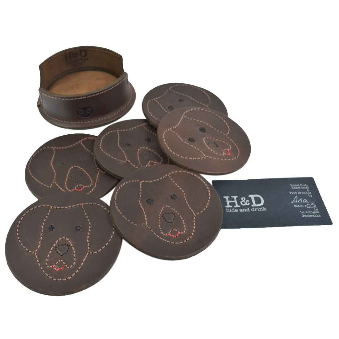 The Labrador Doggy Classic Shaped Coaster Set (6-Pack) by Hide & Drink showcases the coasters along with an informational card about the product. Each coaster features a playful Labrador Retriever design, crafted from full grain leather for durability. Labrador Retriever Doggy/Animal Farm Classic Shaped Coasters (6-Pack) Full Grain Leather, StockyardX, Small Batch Production, Handmade in La Antigua Guatemala & Oaxaca Mexico.