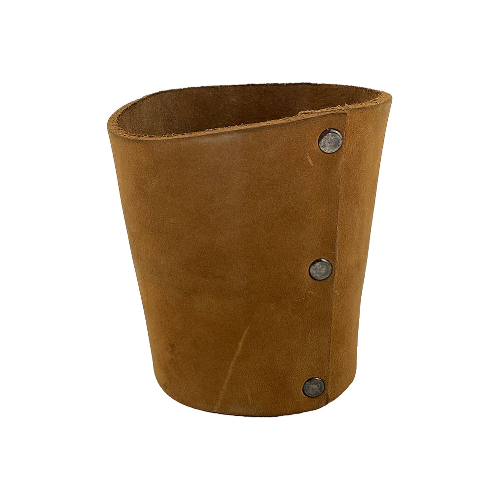 Close-up view of the brown leather Pint Sleeve from Hide & Drink, focusing on its durable construction and classic design. This ideal bar accessory features brass metal rivets, ensuring excellent temperature control for your drinks while being crafted in La Antigua Guatemala & Oaxaca Mexico.