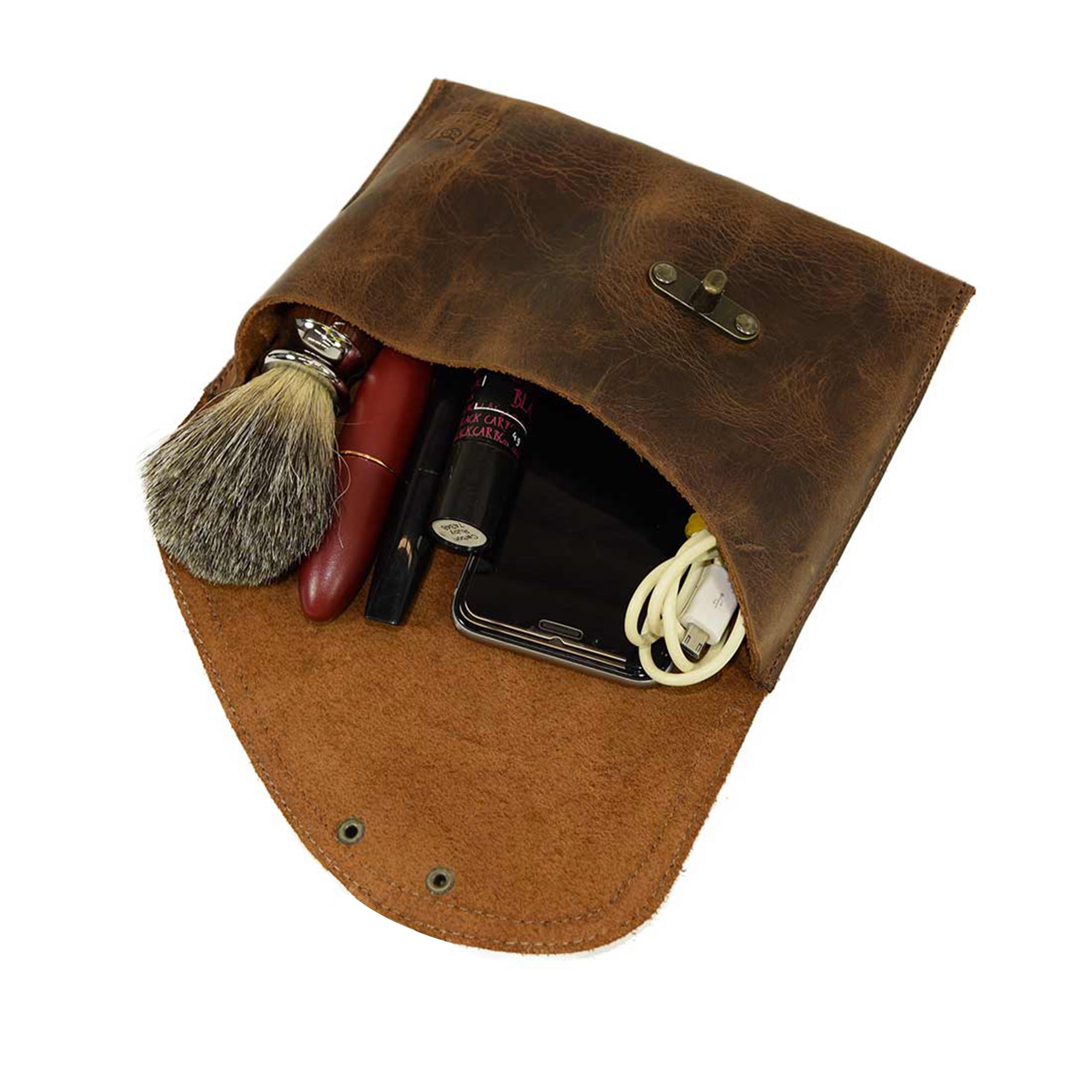 A Vintage Clutch Bag from Hide & Drink showcasing its interior filled with essentials, crafted from Full Grain Leather with artisan flair, handmade in La Antigua Guatemala.