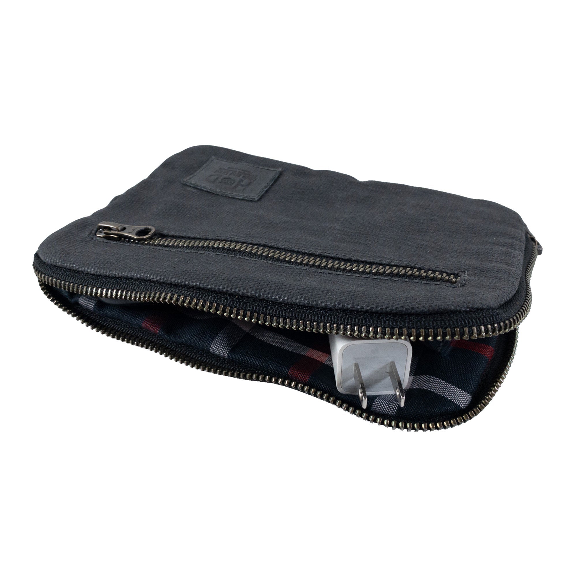 Interior layout of Hide & Drink's dark brown Zipper Gear Pouch illustrating organization of cables and tech, emphasizing its durability and handmade quality from water resistant waxed canvas.