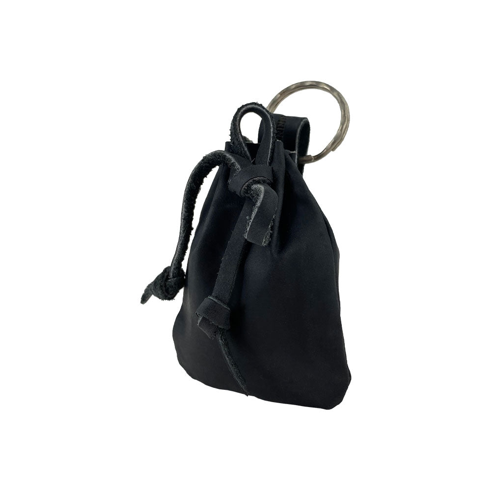 Coins spilling from the Mini Medieval Pouch Keychain by Hide & Drink, showing its functionality. This tiny bag with keyring, made from full grain leather, doubles as a coin organizer, highlighting artisan craftsmanship from La Antigua Guatemala.
