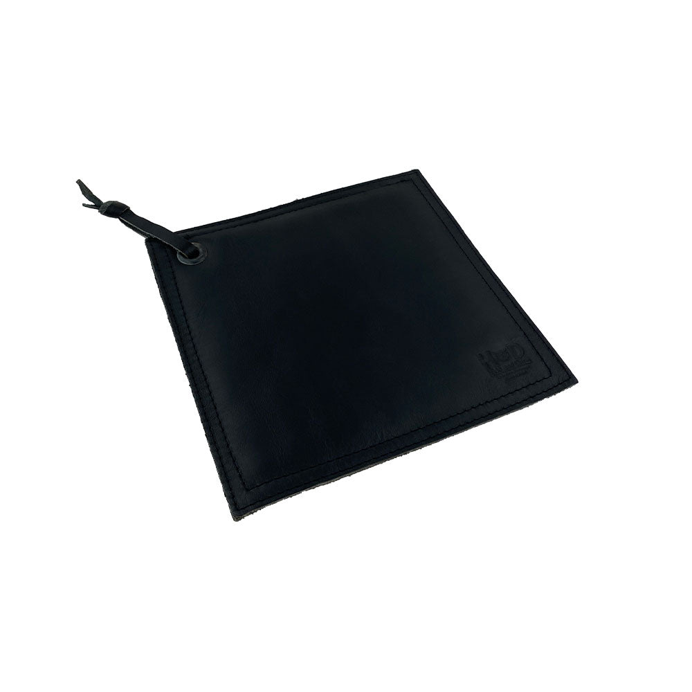 Side view of the Hide & Drink Pot Pad, emphasizing its quality and rustic design. This double-layered full grain leather potholder is perfect for protecting surfaces from hot cookware.