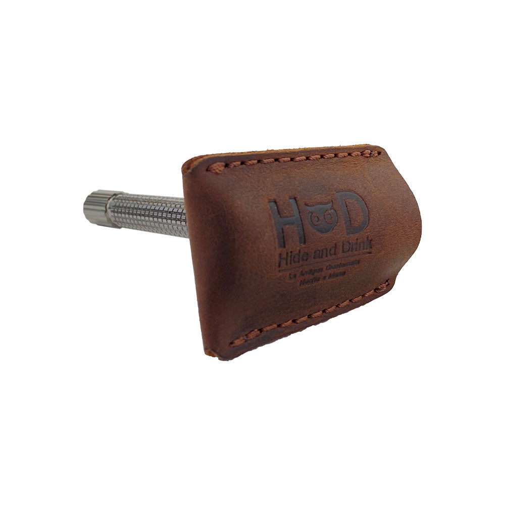 Hide & Drink Razor Head Cover on a double edge safety razor, illustrating its fine stitching and protective design. This handmade, full grain leather cover is perfect for shaving travel, crafted by artisans in La Antigua Guatemala & Oaxaca Mexico.